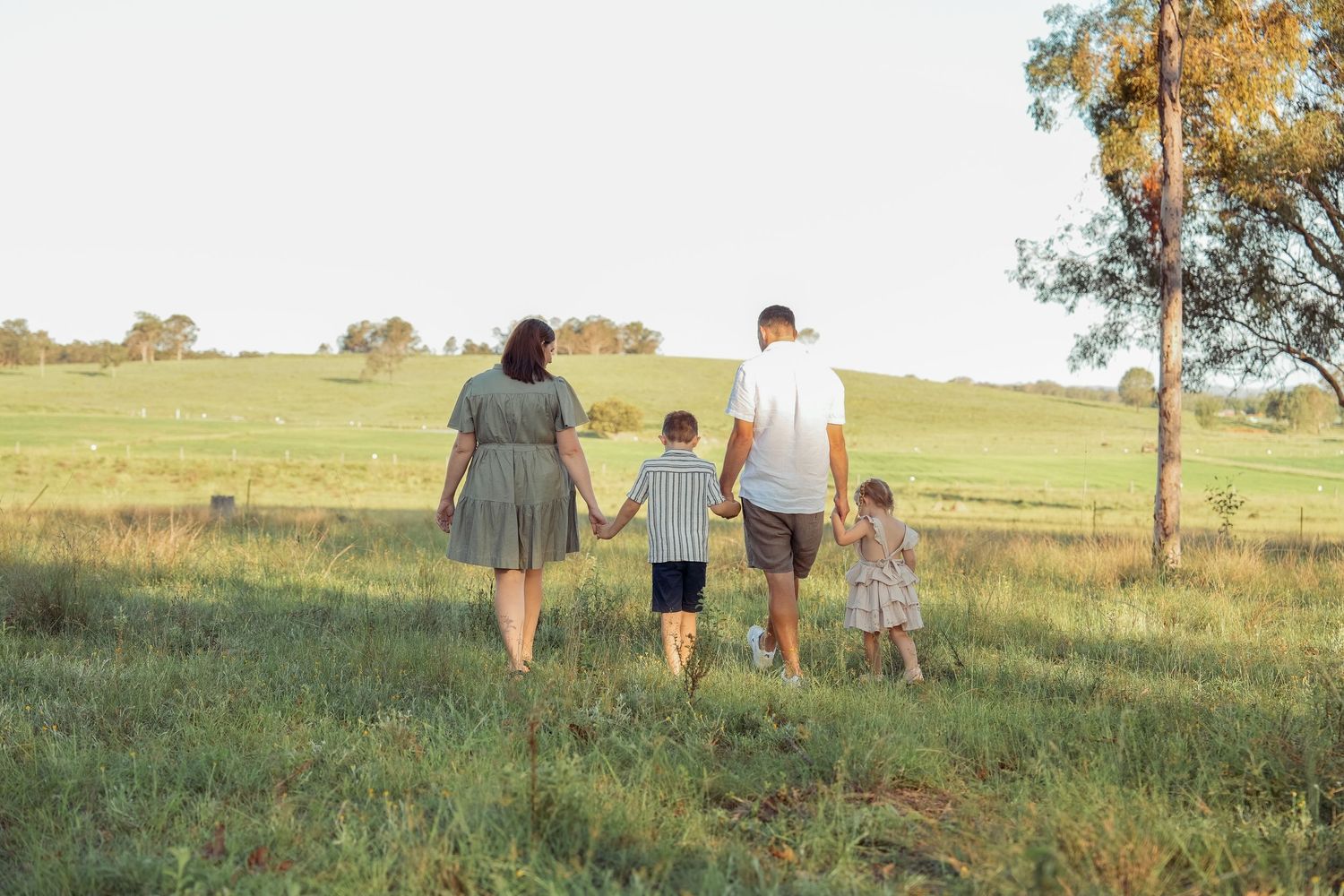 Family holding hands walking together during golden hour family session