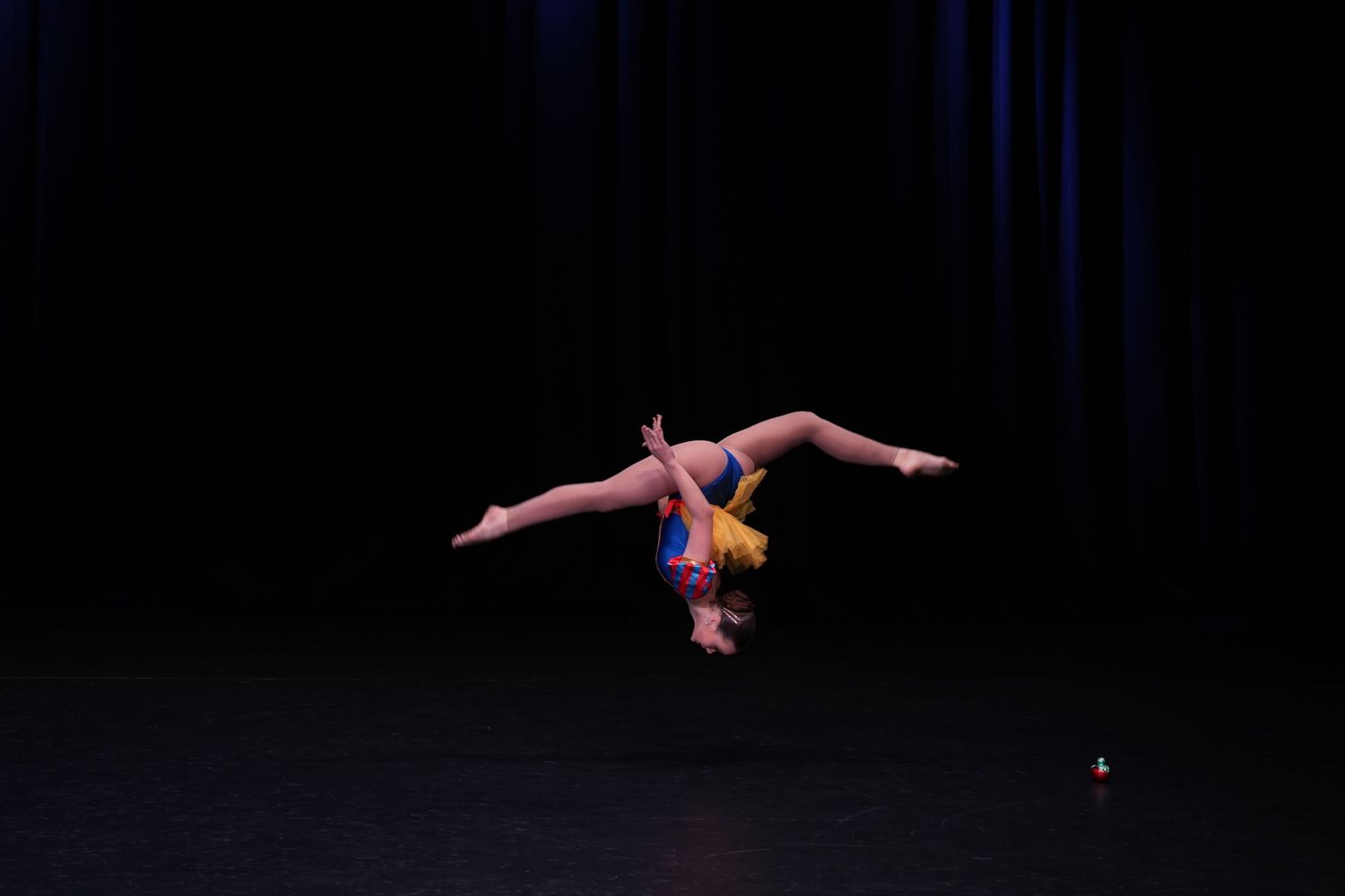 Dancer performing an impressive aerial skill during a dance competition