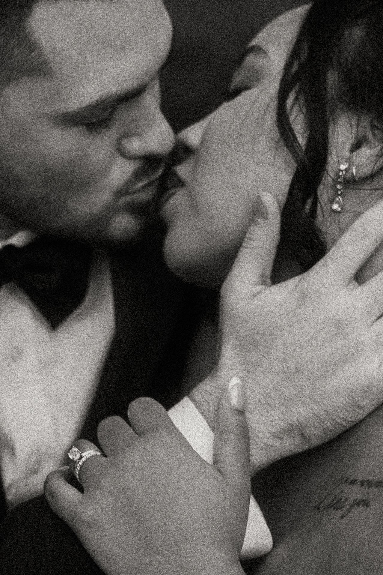 Intimate black and white close-up of bride and groom sharing a kiss on their wedding day.