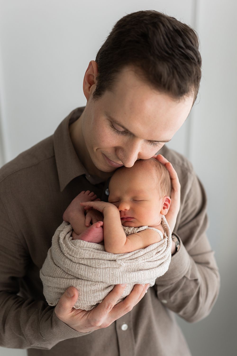 A father holding a newborn baby.