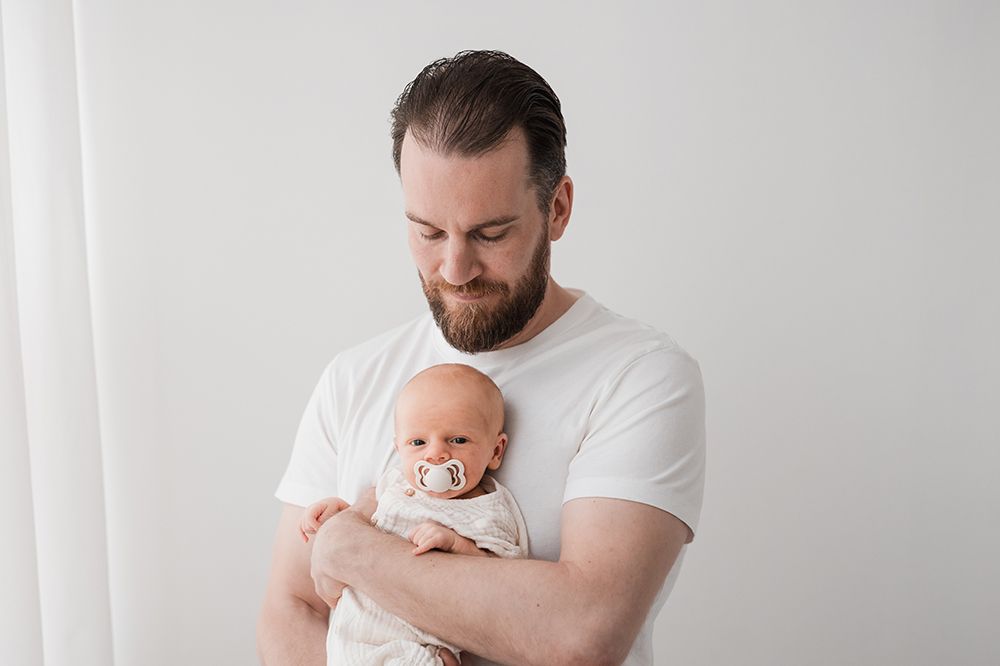 A father holding a newborn baby.