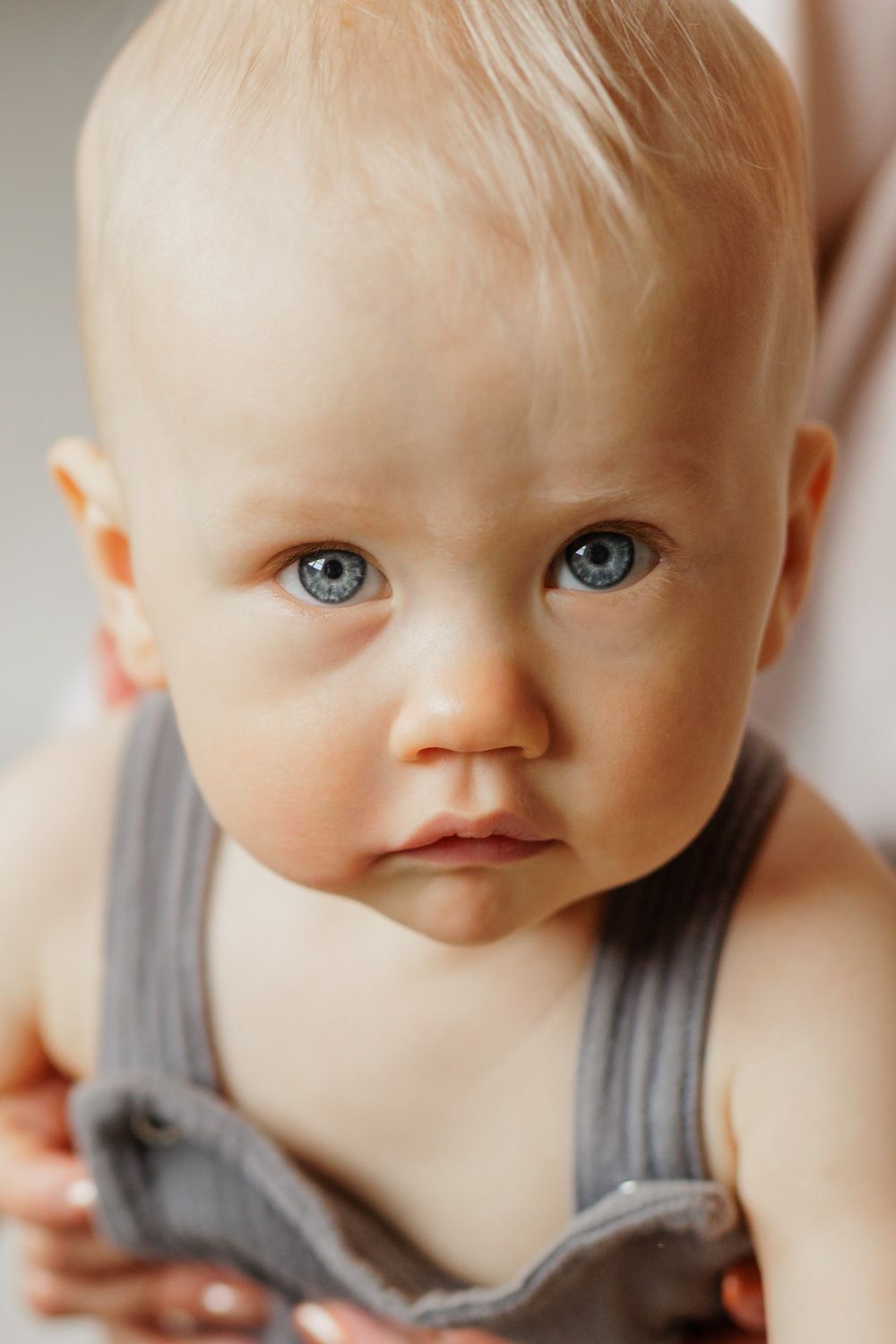 A baby boy looking at a camera.