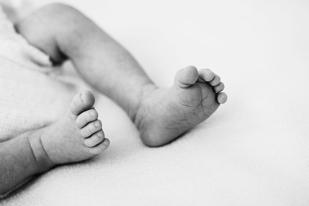 Newborn baby feet close up back and white.