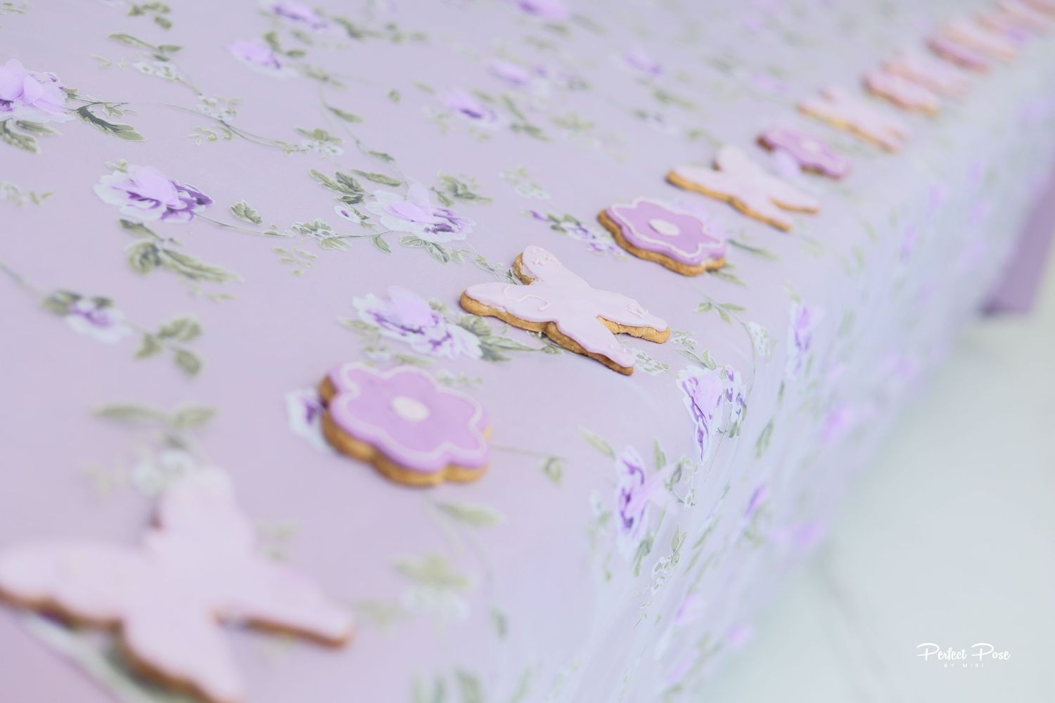Pink floral gift box with purple butterfly decorations and golden letter accents on a soft lavender background.