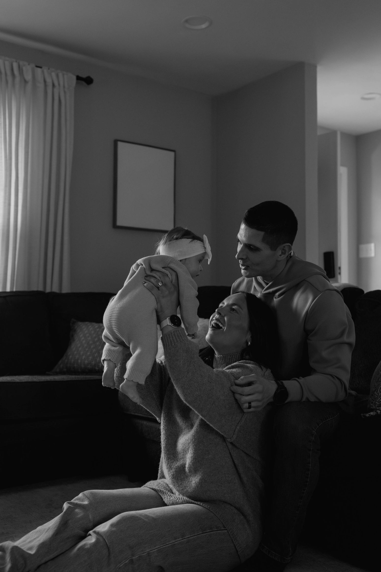 mom dad and baby playing in their house