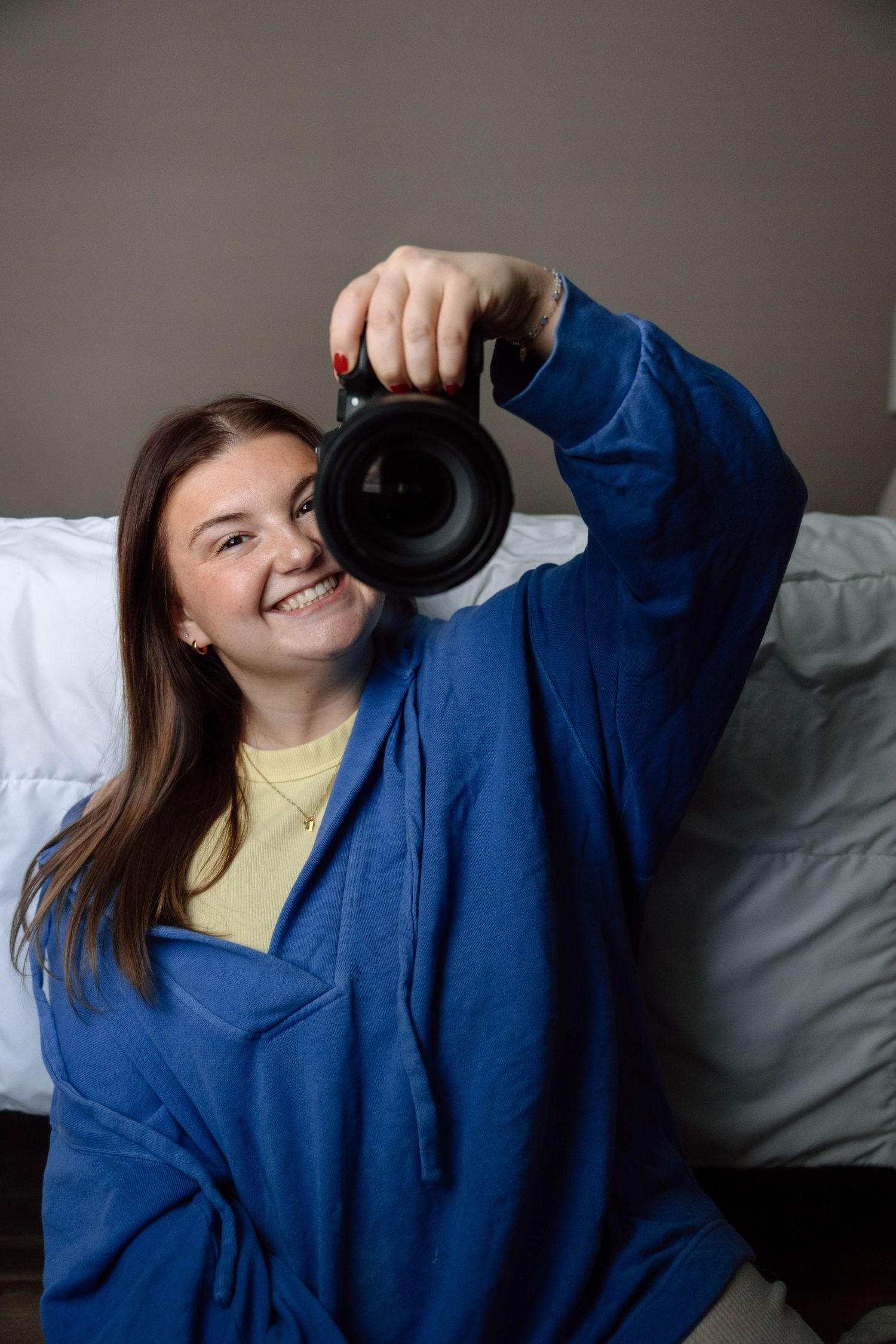 girl taking photo of self in mirror with large camera