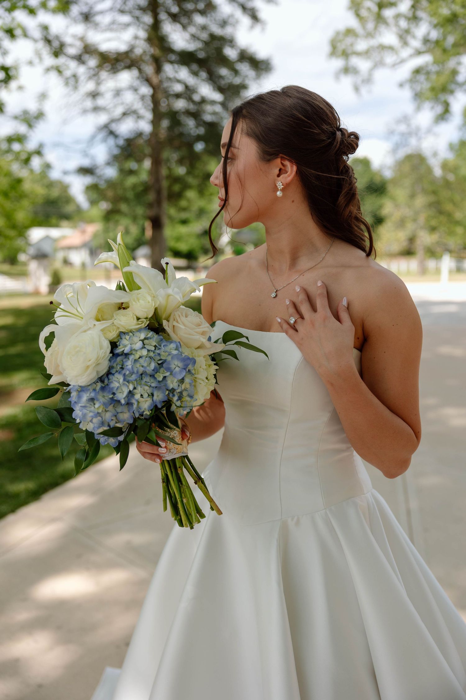 Bride with large bouquet looking away from camera.