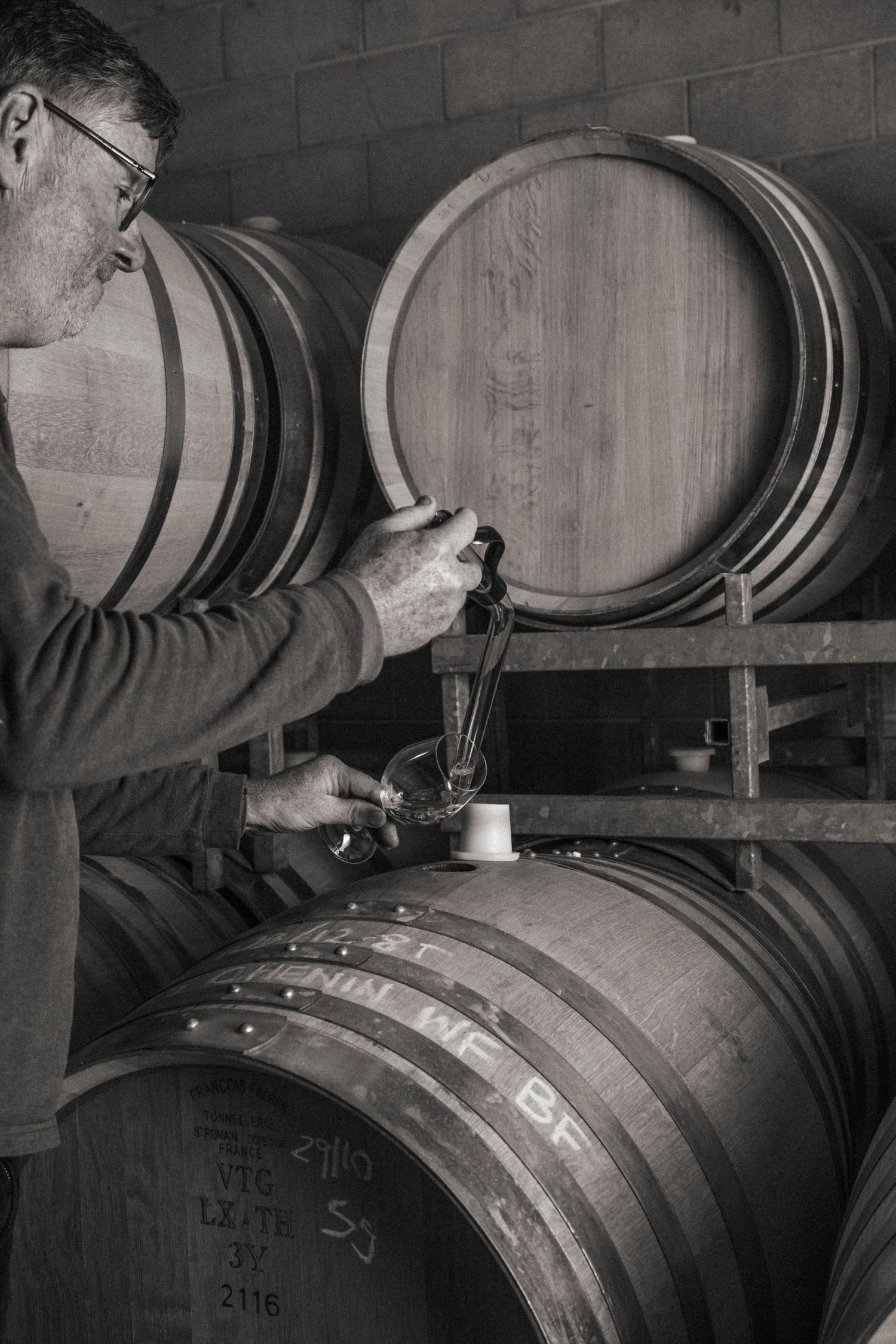 Winemaker pouring wine from oak barrels at Yarra Valley winery cellar door in Victoria