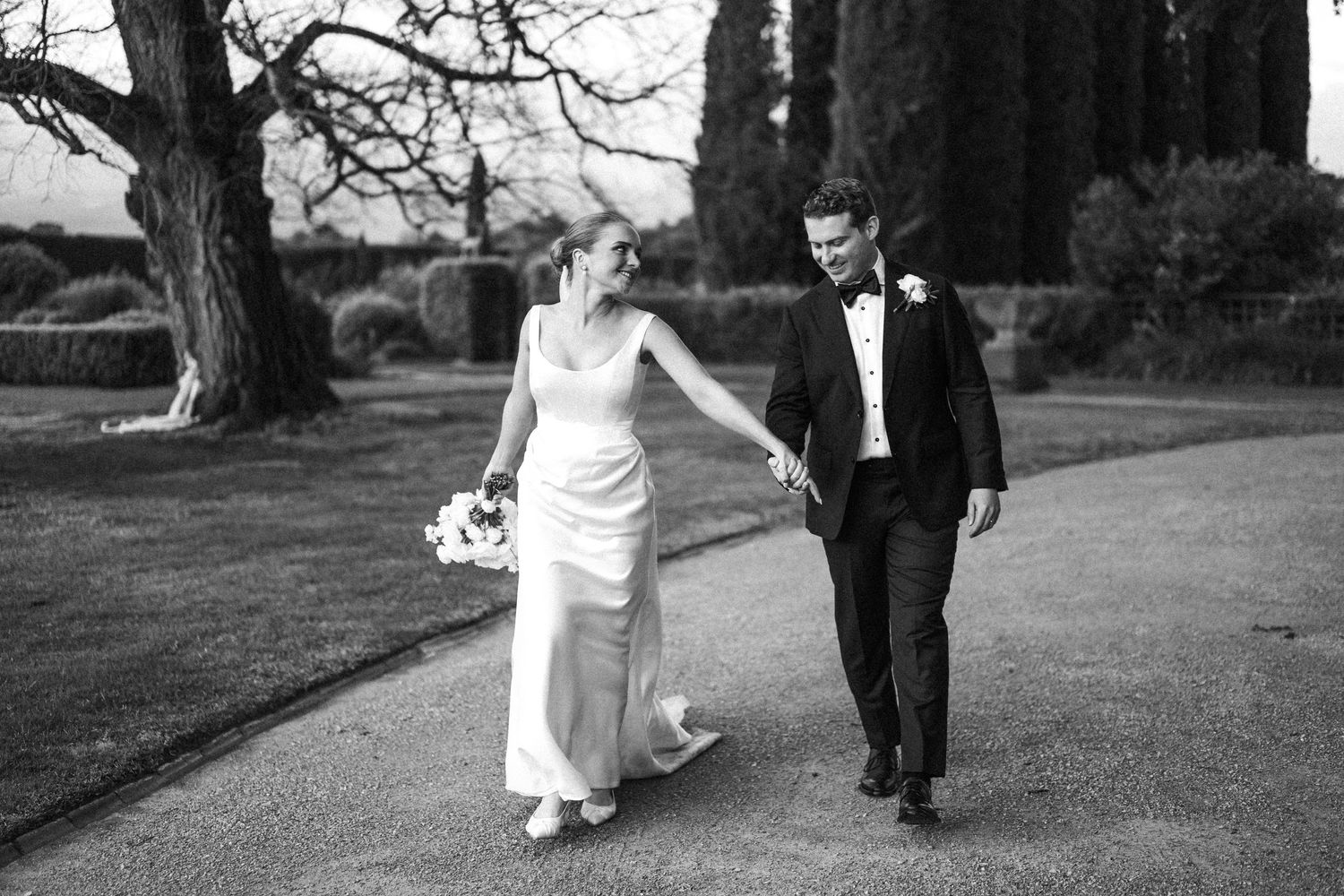 Classic black and white wedding portrait of couple walking on country estate