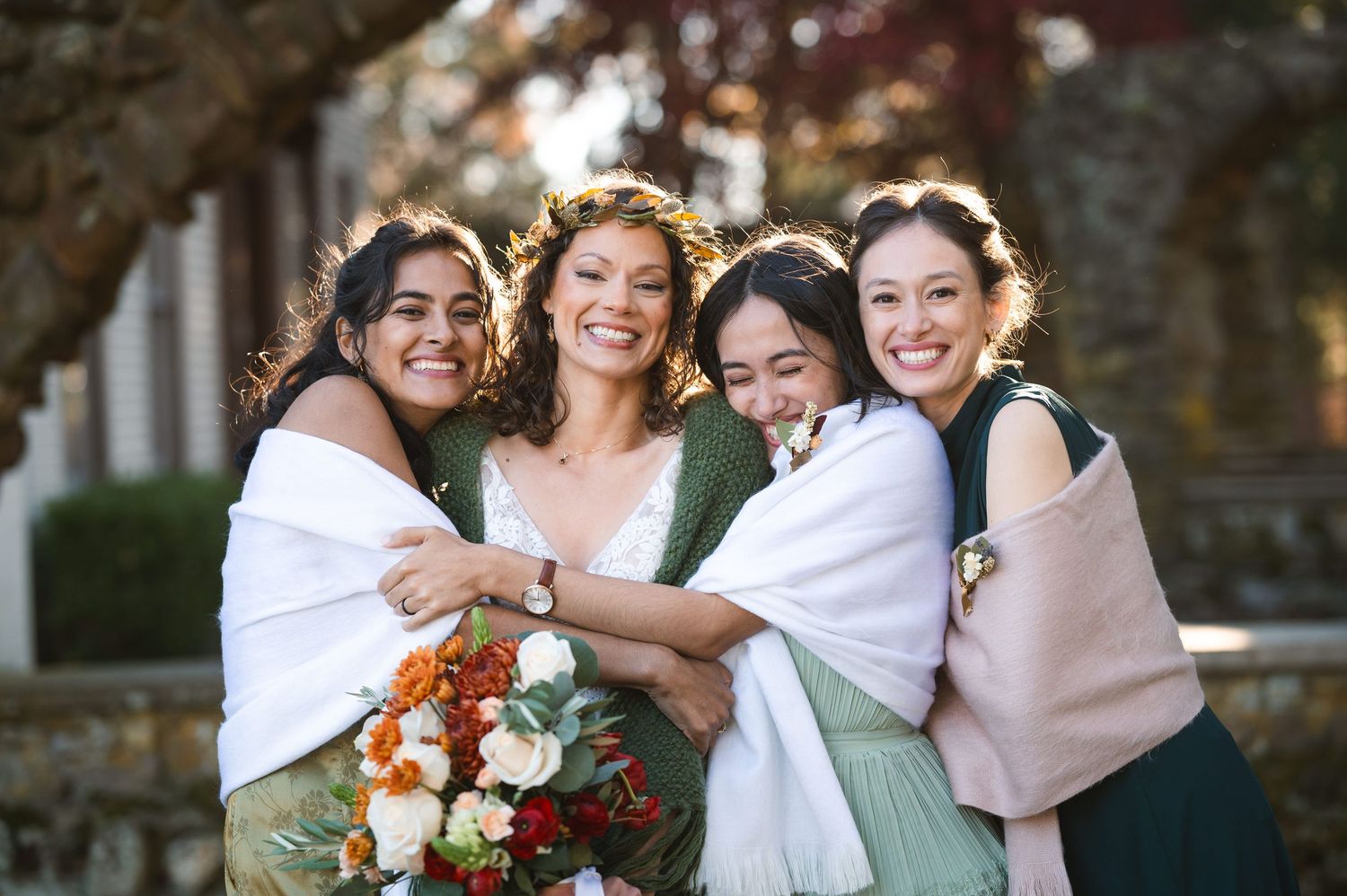 Bride and her attendants share joyful embraces and laughs while wearing pink and sage green dresses at Brotherhood Winery Washingtonville NY