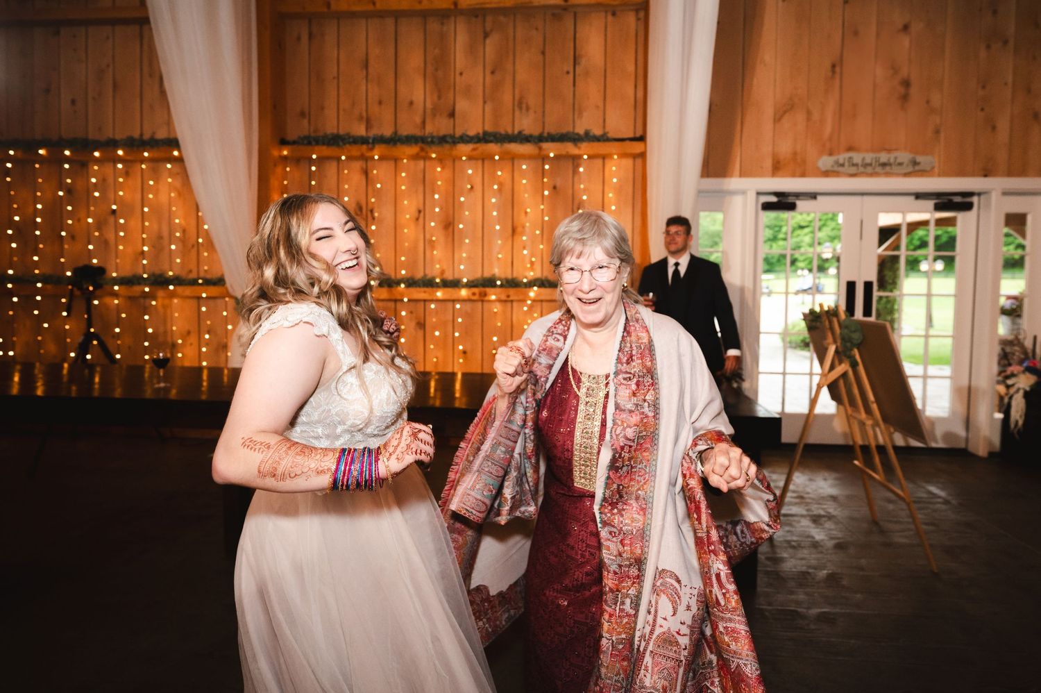 Bride and grandmother dance in joyful moment at wedding reception in rustic barn at Fortune Valley Manor Saugerties, NY in the Hudson Valley