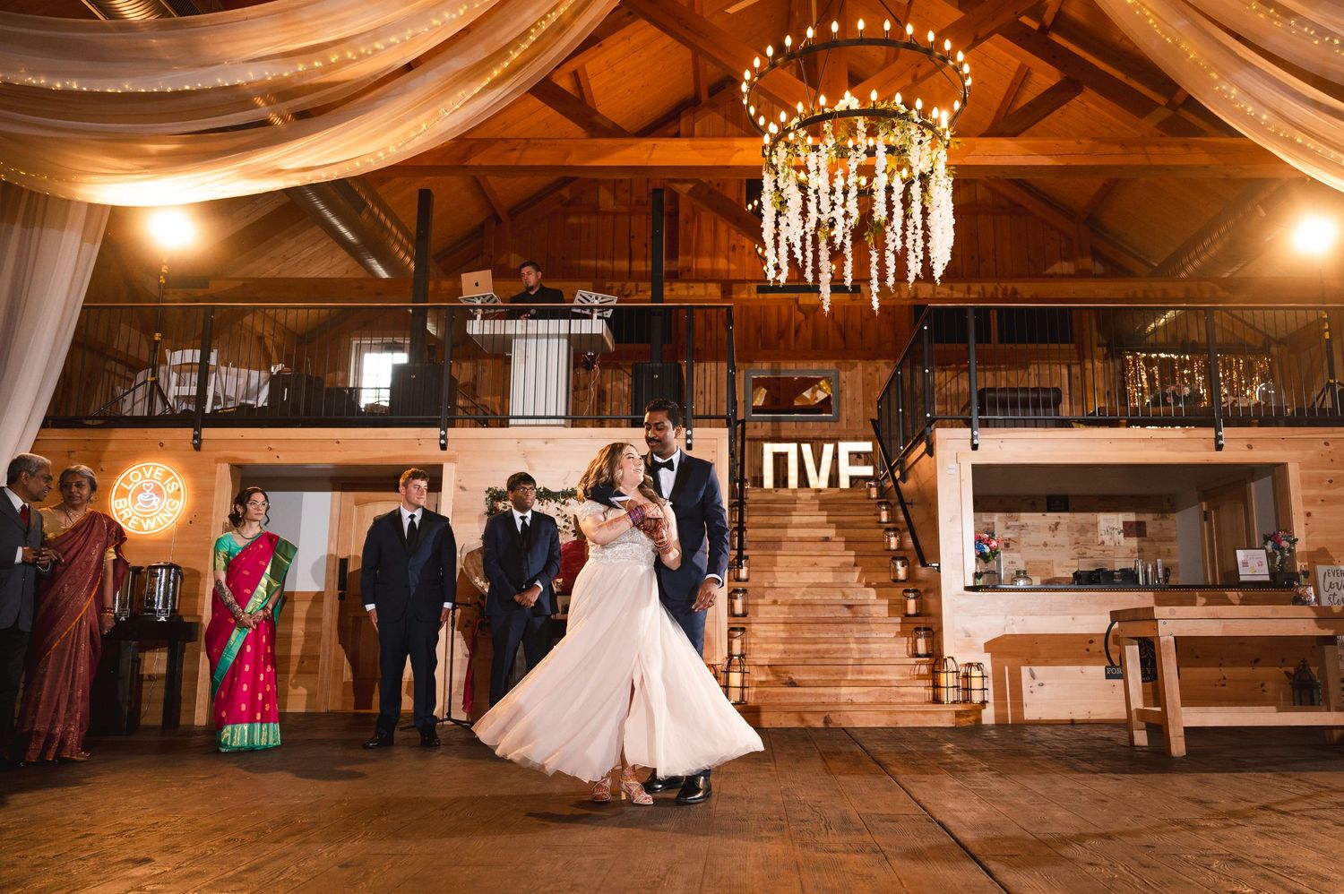 Reception venue with elegant chandelier and rustic wood beams as dancers celebrate on the dance floor at Fortune Valley Manor in Saugerties.