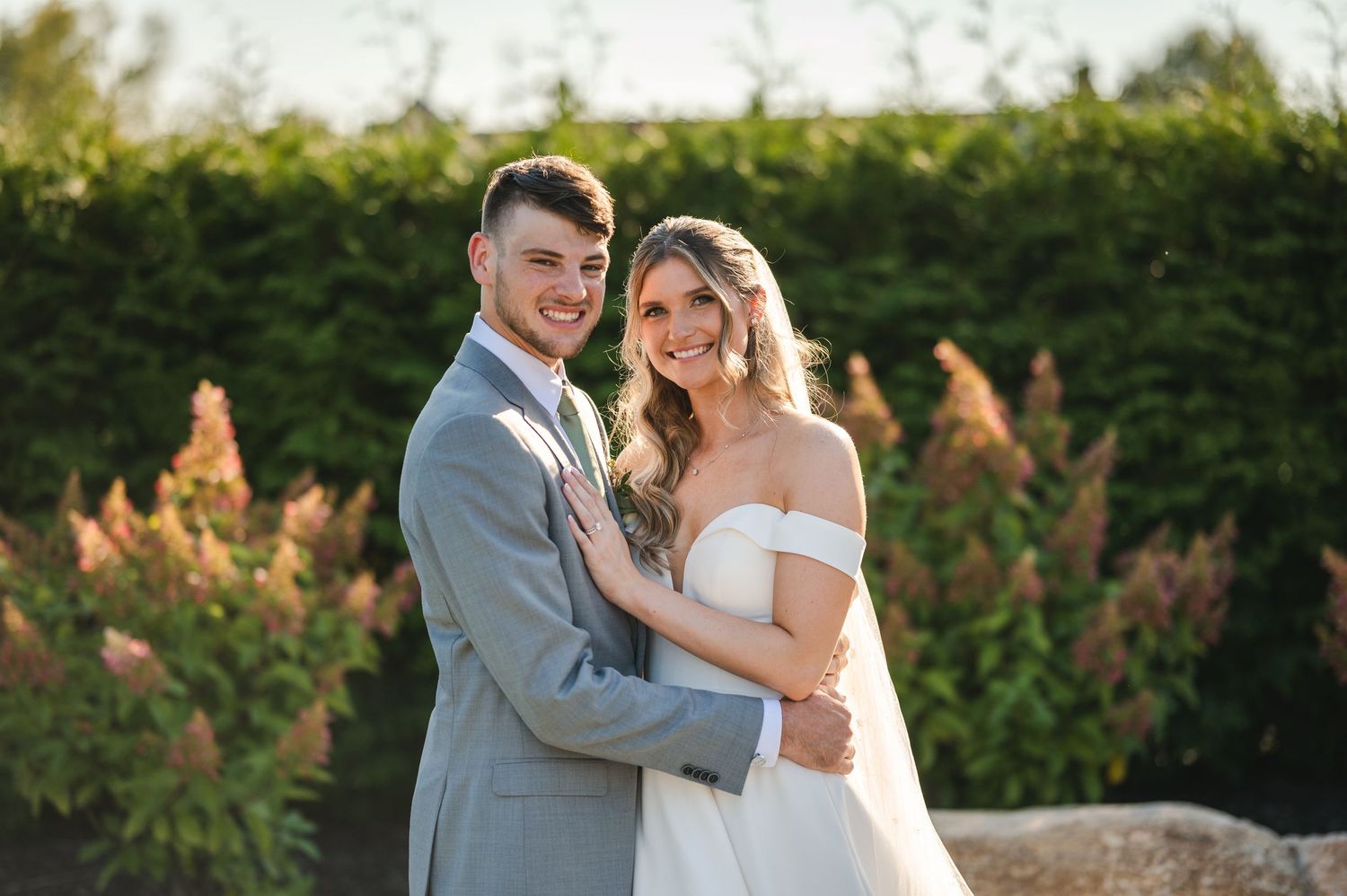 Couple wedding portrait during golden hour surrounded by greenery on patio of The Barn at Villa Venezia in Middletown, NY in Hudson Valley.