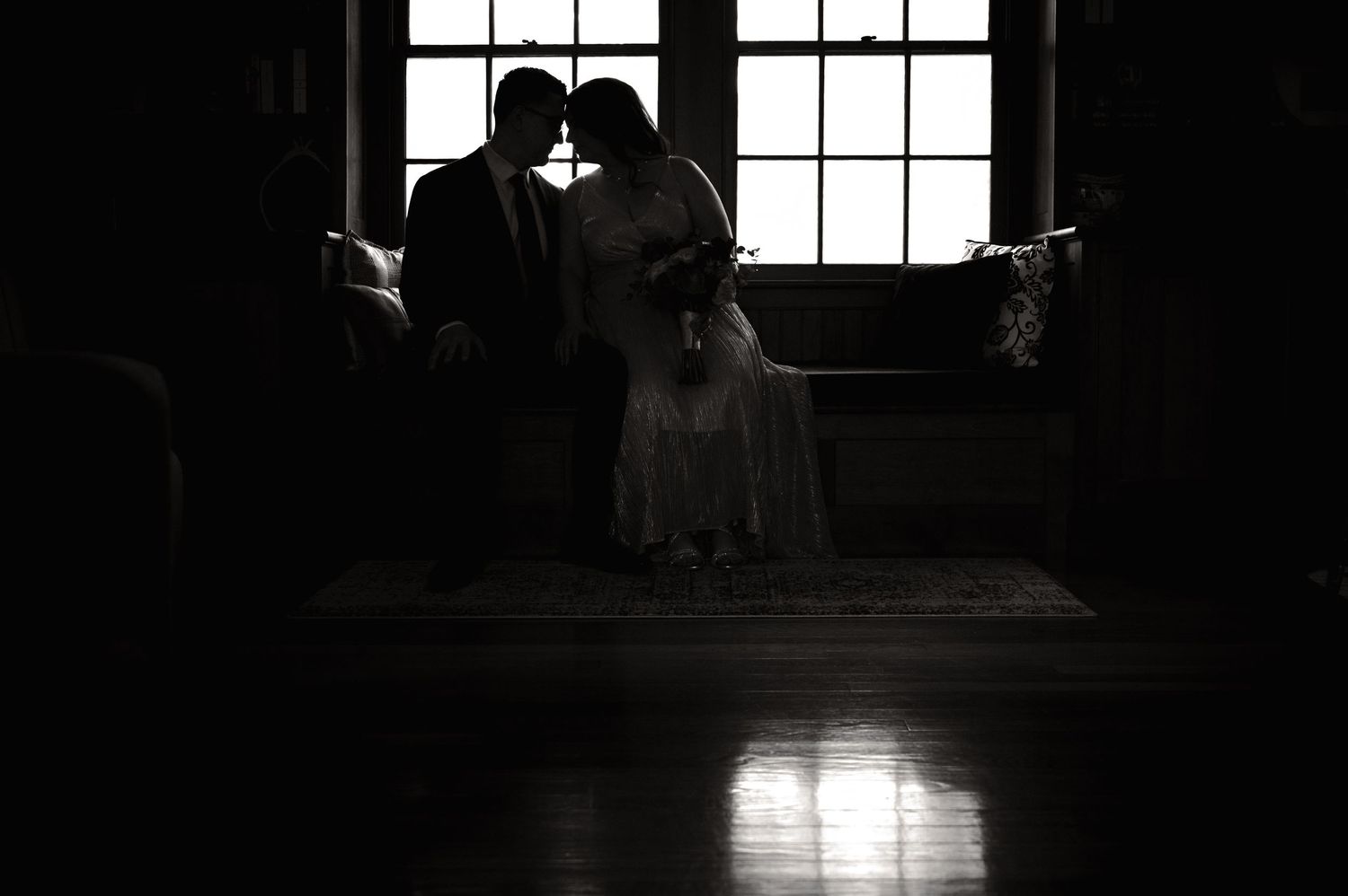 Silhouette of bride in groom at an elopement in front of large windows in their Airbnb prep house in Yorktown, Westchester NY, Hudson Valley