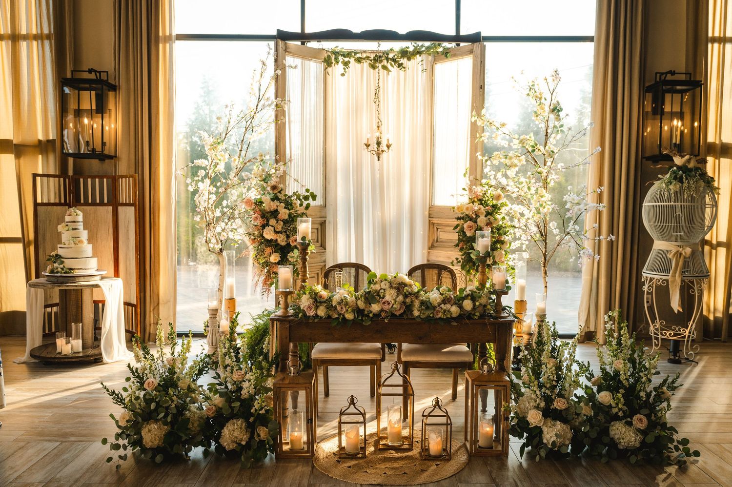 Rustic wedding ceremony sweetheart table setup with wooden table, floral arrangements and greenery at The Barn at Villa Venezia Middletown.