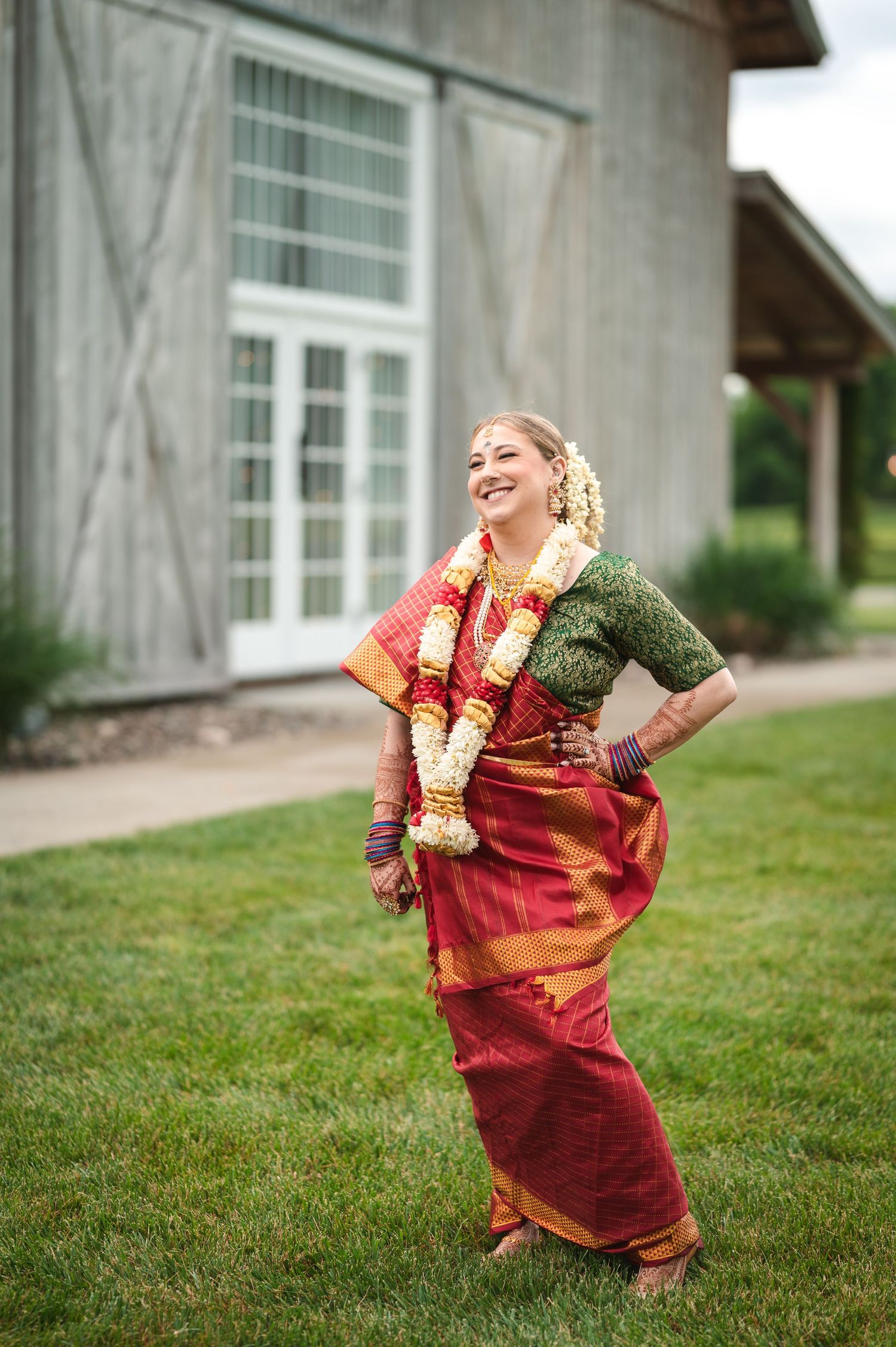 Laughing bride in Indian saree in front of modern at Fortune Valley Manor in Saugerties, NY in the Hudson Valley.