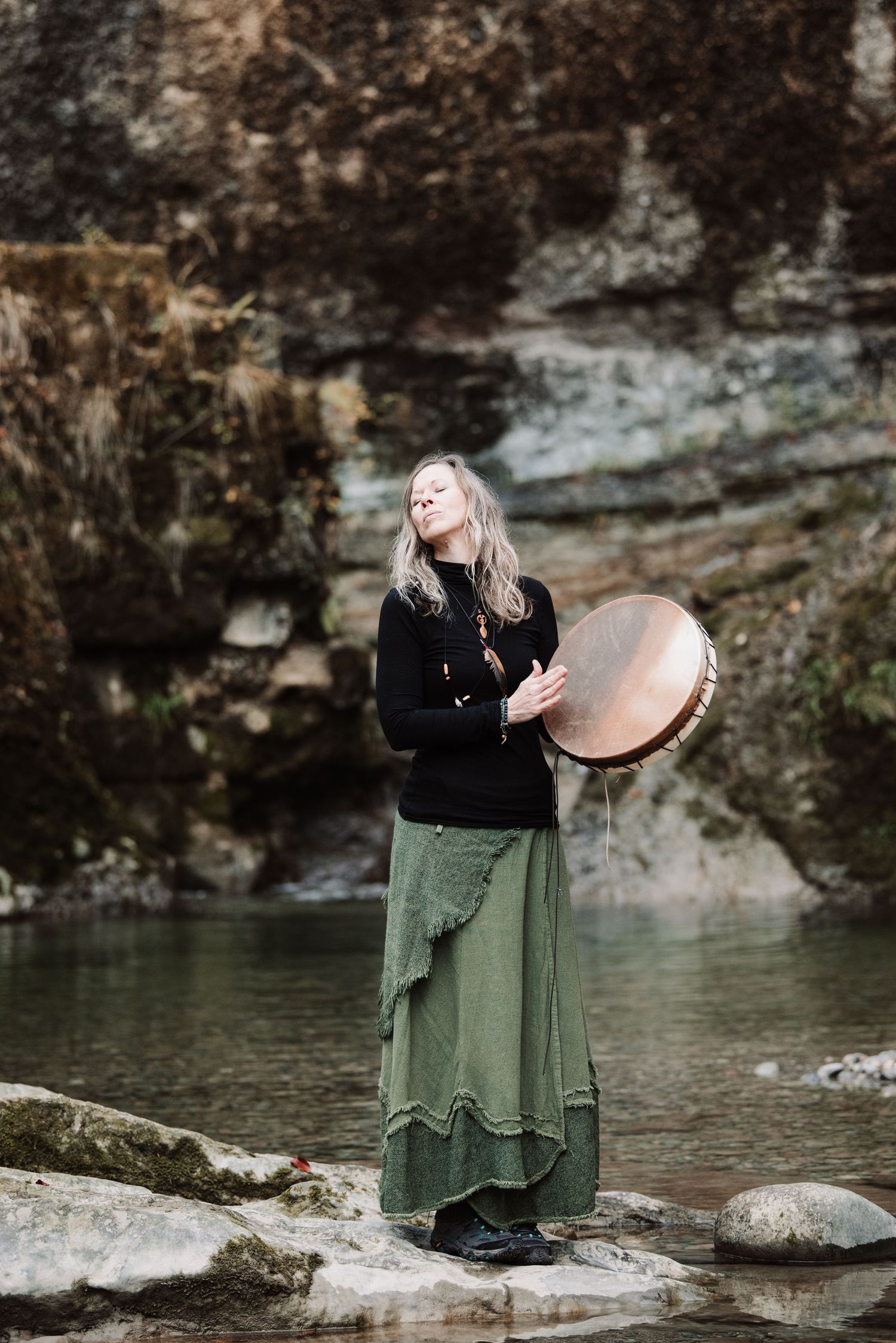 Frau mit Trommel am Wasser