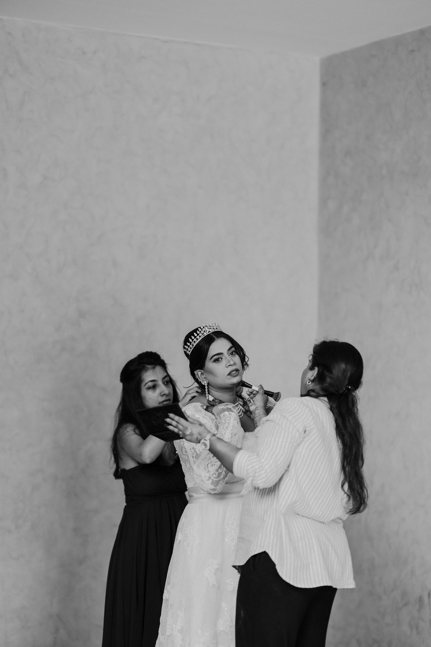A black and white photo sequence showing three people in dramatic poses against a plain wall.