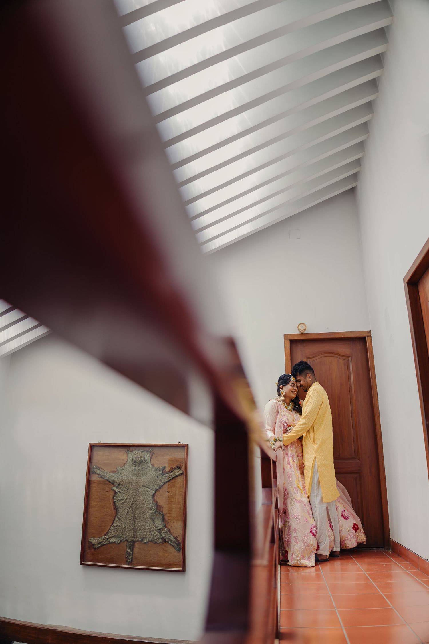 A series of artistic photos showing a couple in traditional wedding attire posing against white walls with geometric shadows.