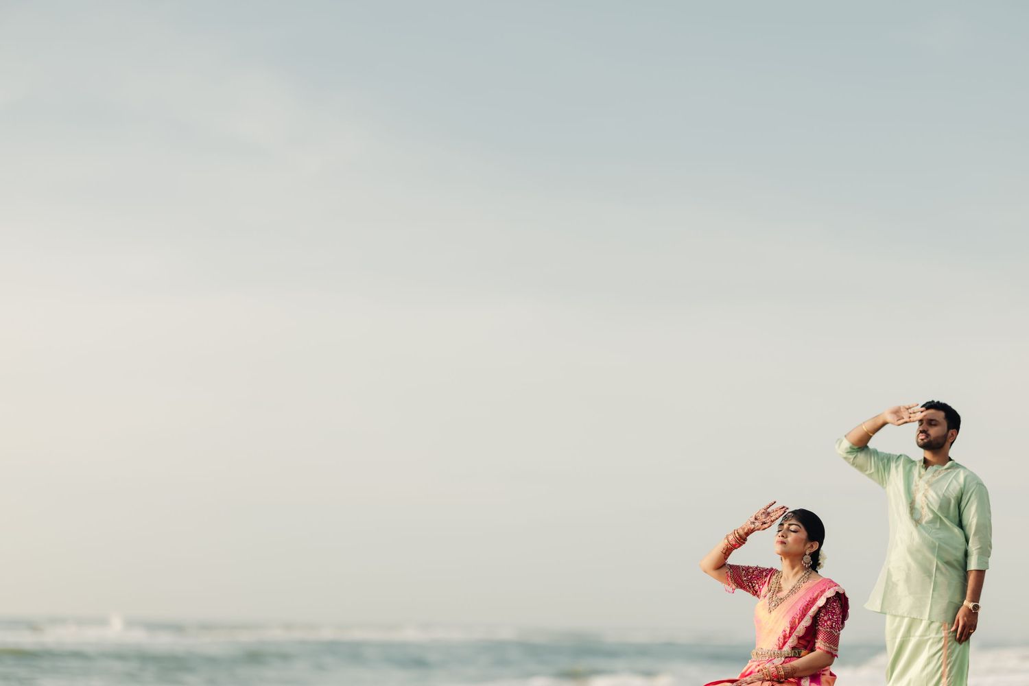 Figures silhouetted against pale sky in candid beach scene.