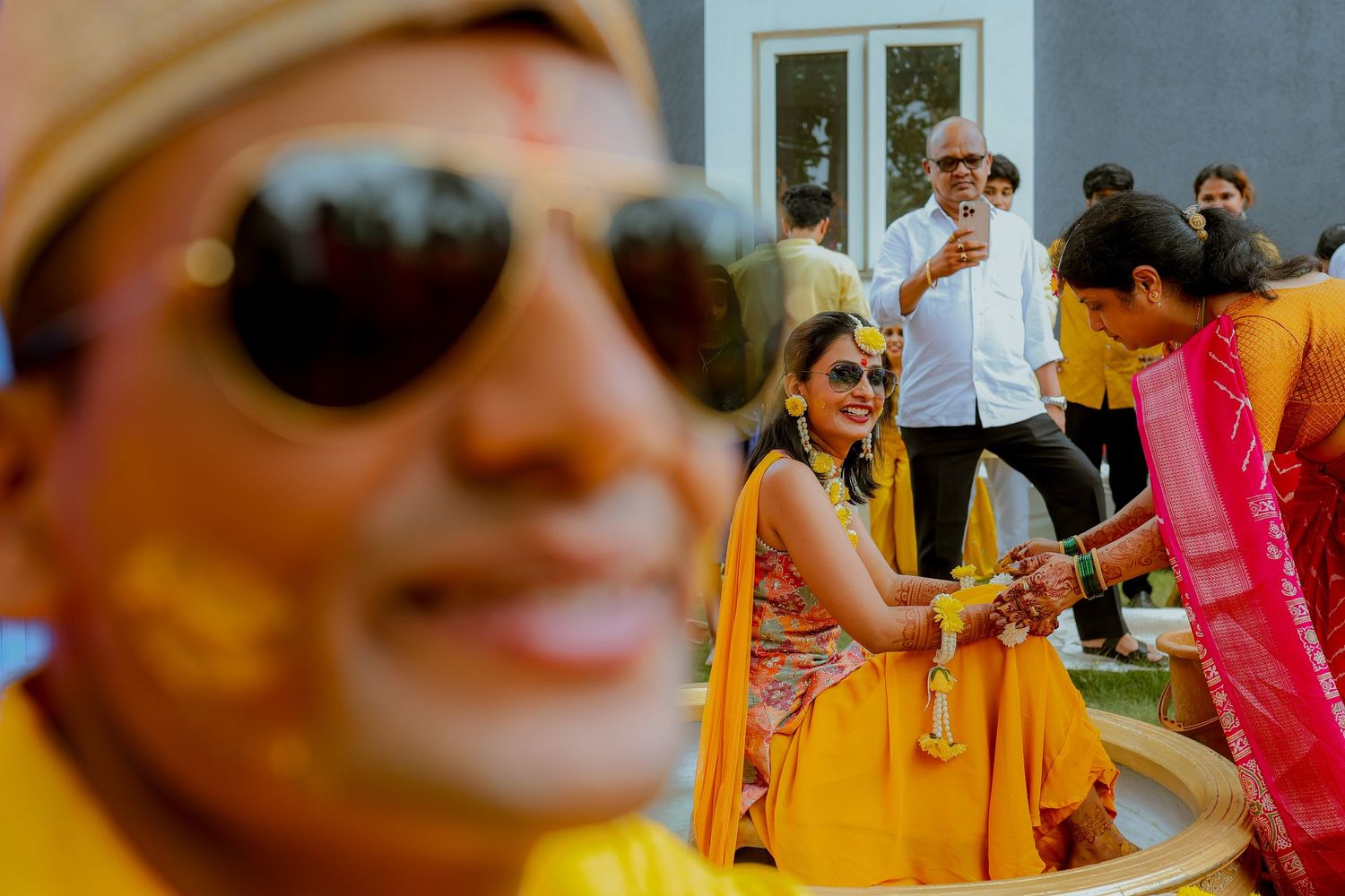 A series of candid moments at a festive outdoor celebration showing people in bright traditional attire and sunglasses.