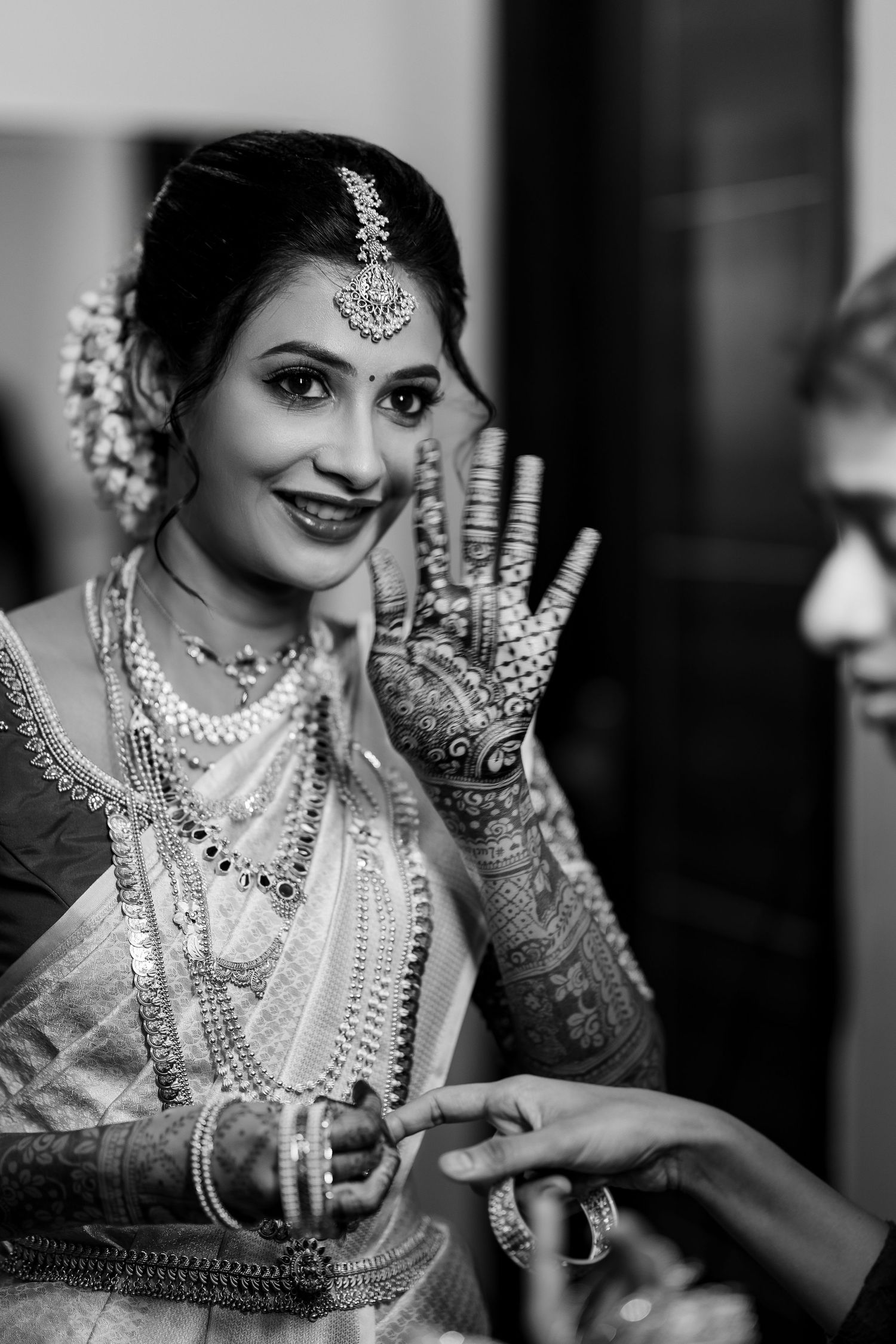 Black and white photos show a bride in traditional Indian wedding attire with intricate jewelry and mehndi designs.