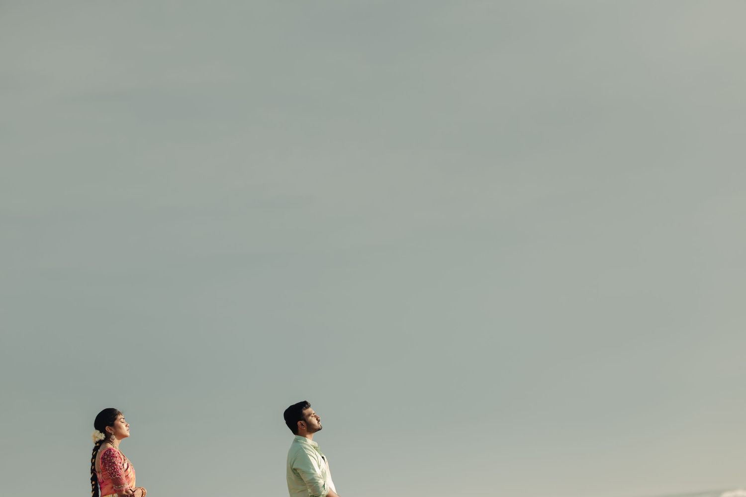 A romantic beach scene with two people enjoying a peaceful moment by the ocean.