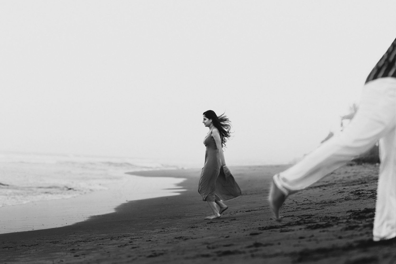 Minimalist beach scene with flowing white fabric in the wind.