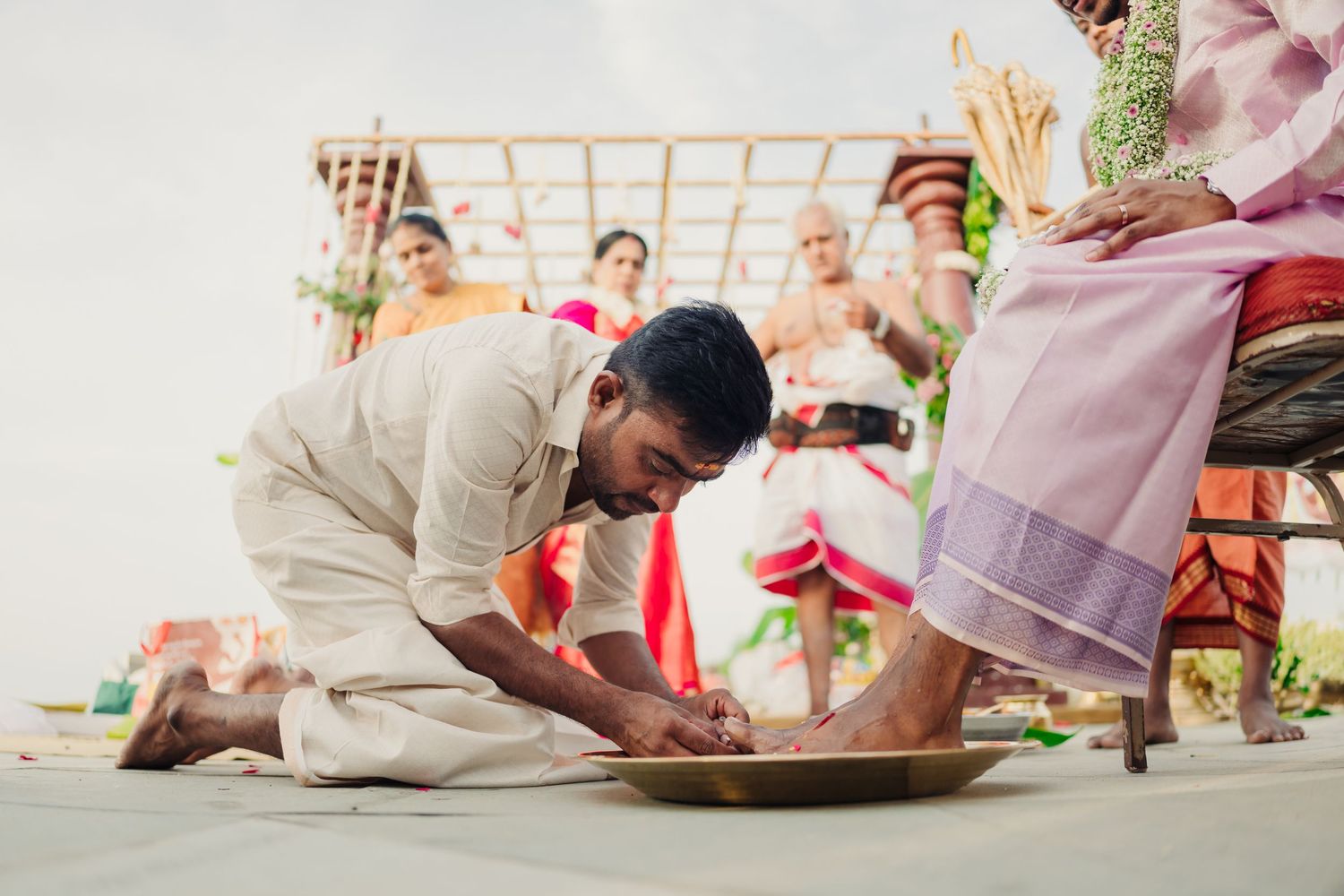 Traditional Indian wedding ceremony shows couple performing sacred rituals on decorated mandap stage.