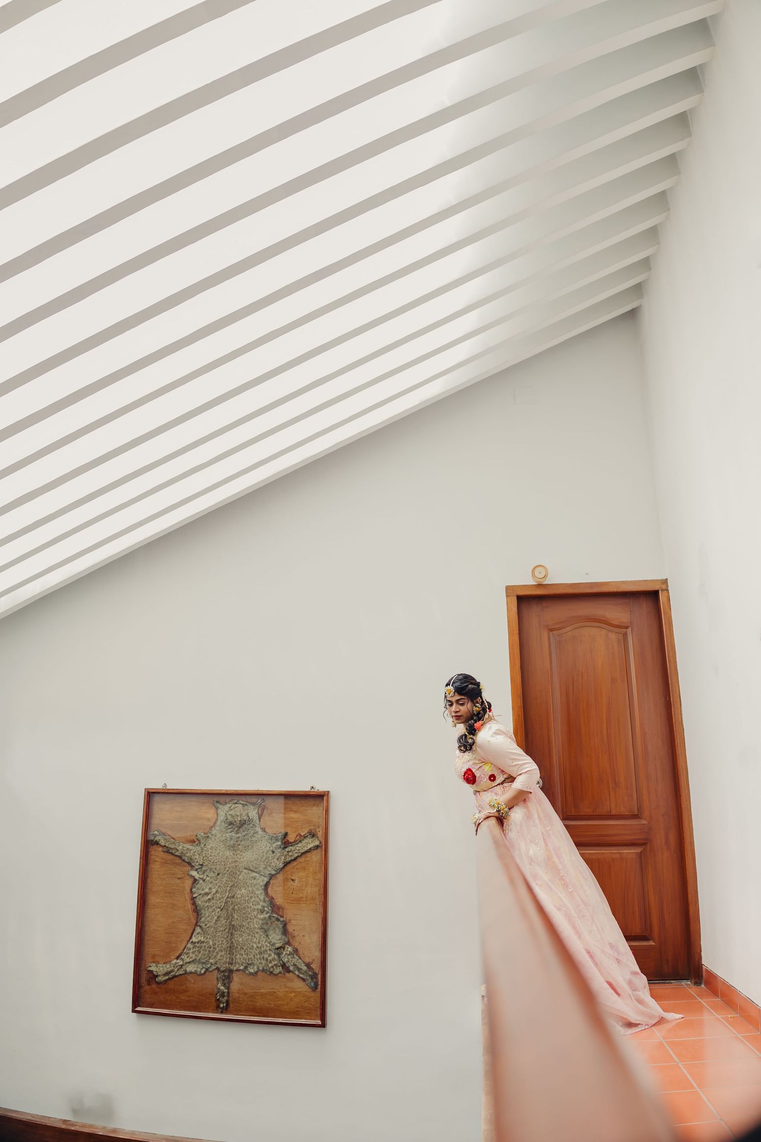 A series of minimalist architectural photos showing white walls, wooden doors, and framed artwork in sequence.