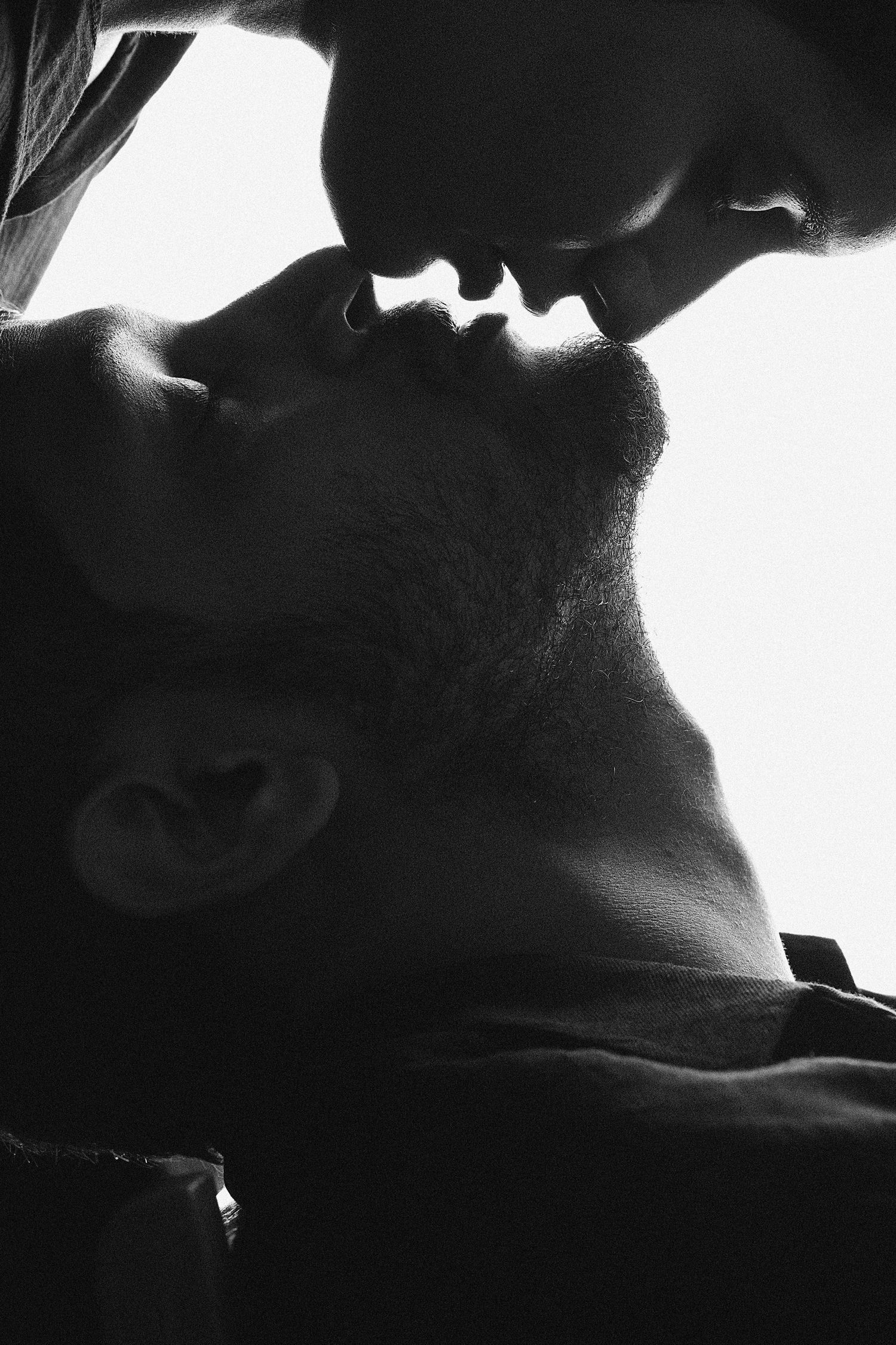 Dramatic black and white silhouette profiles against bright background.