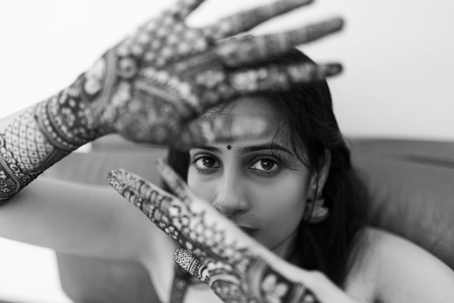 Black and white collage of close-up portraits showing hands framing faces in artistic compositions.