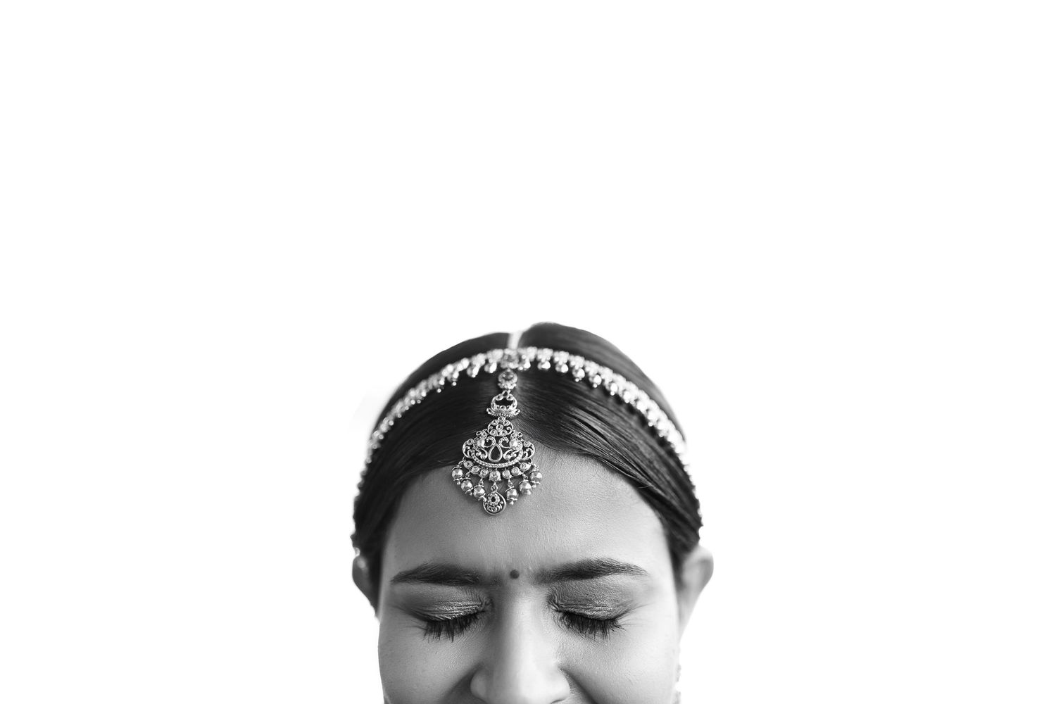Elegant black and white portrait showing decorative jewelry and headpiece details.