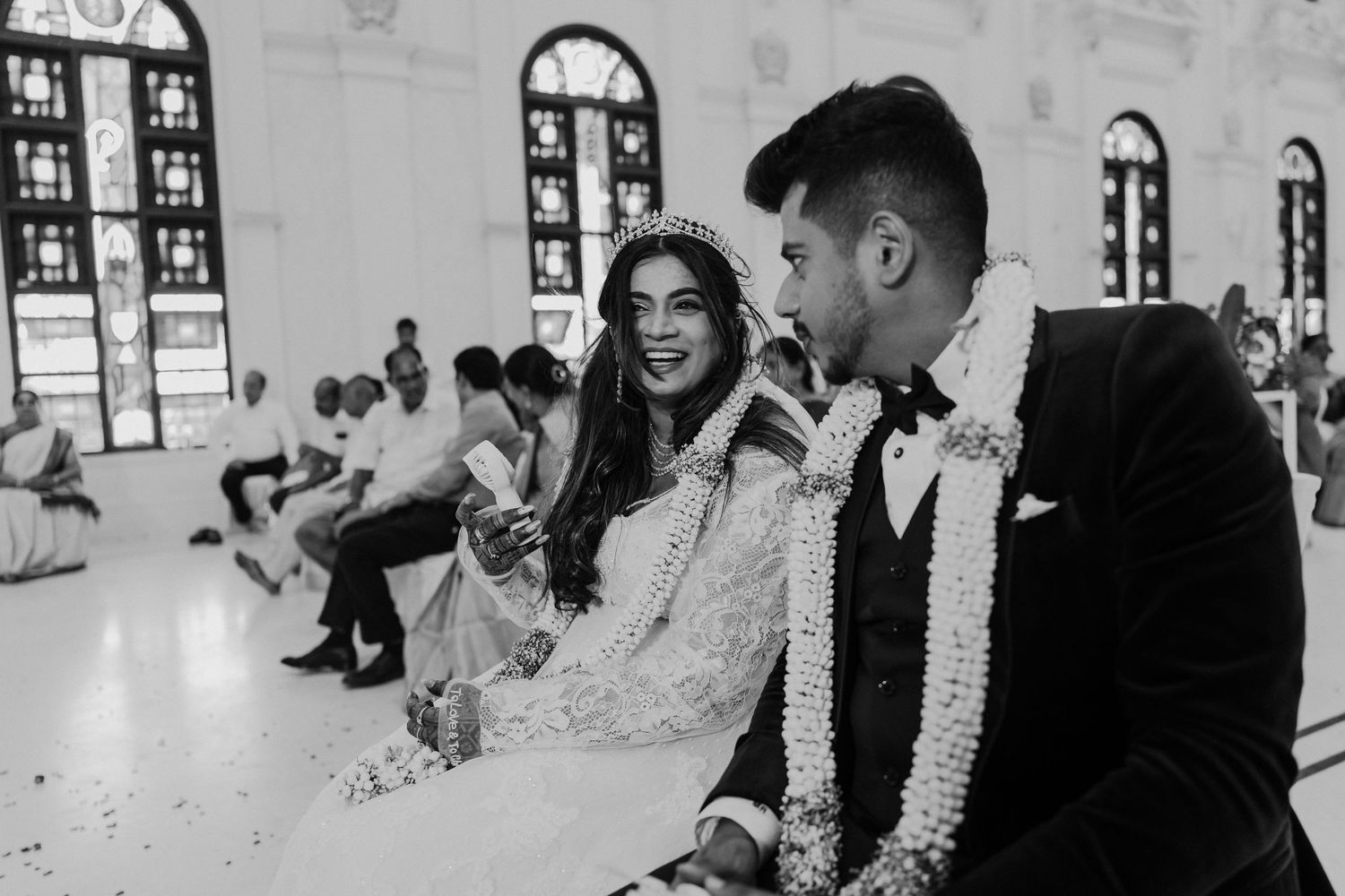 Black and white photo of newlyweds sharing a moment during their church ceremony.
