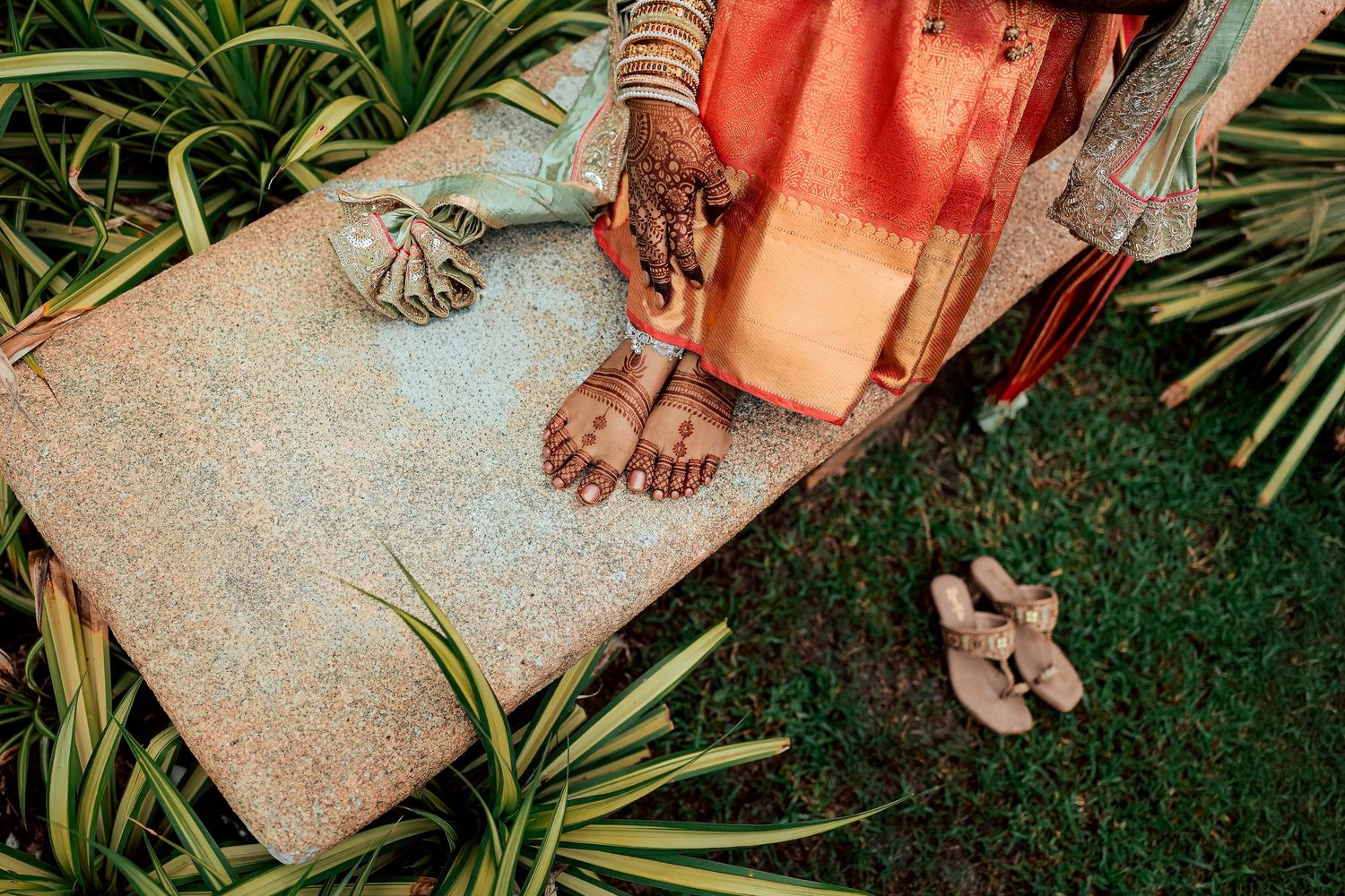 Orange traditional attire details against green grass background.