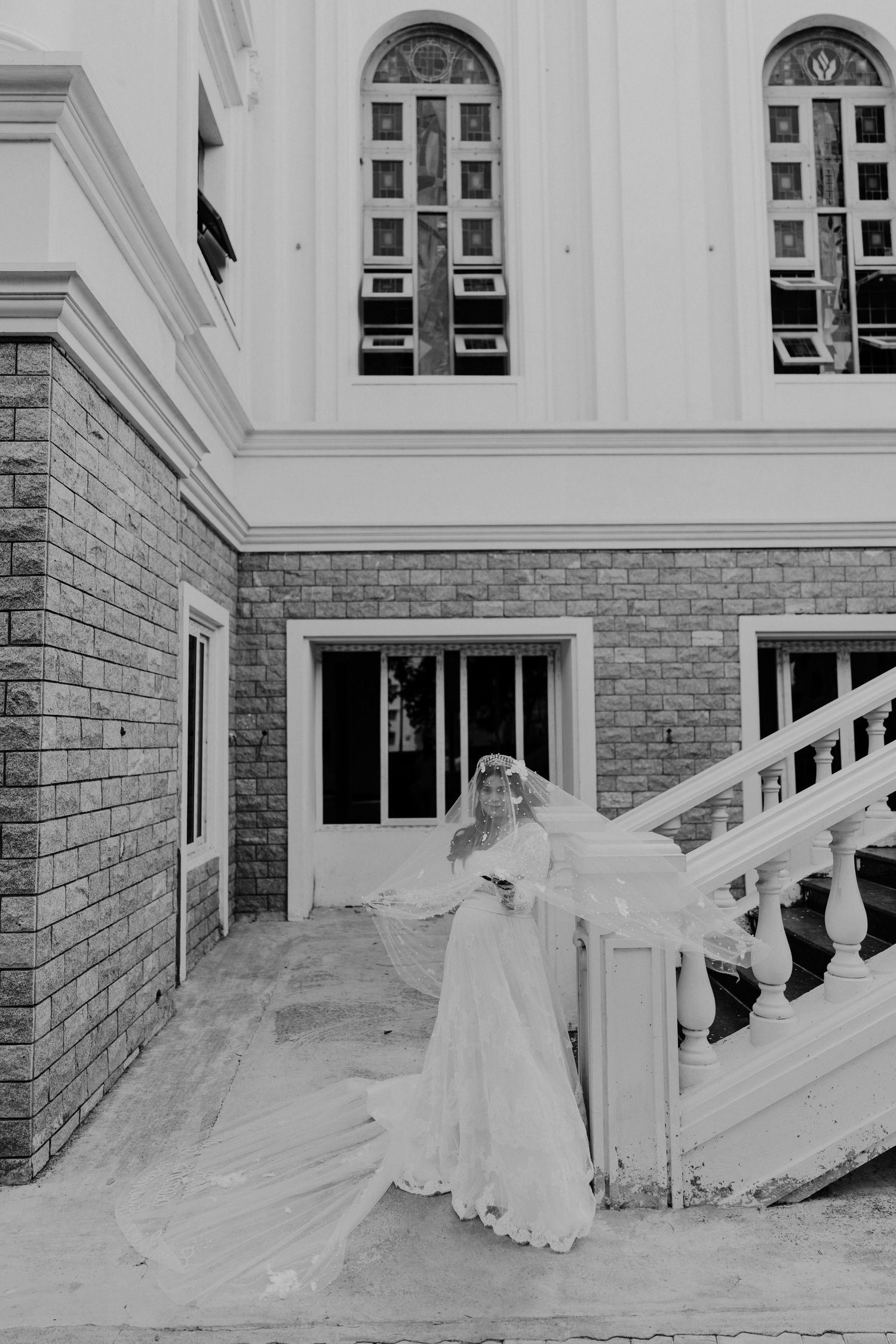 A series of black and white photos showing a flowing white wedding dress on grand white stone steps.