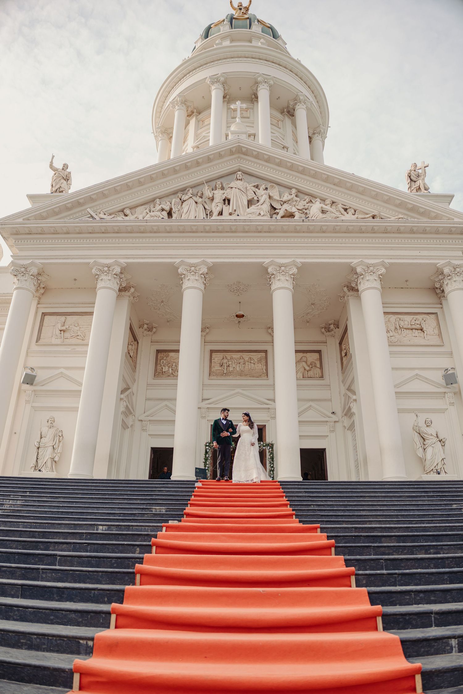 A grand white classical building with columns and a red carpet staircase shown in progressive wedding ceremony shots.