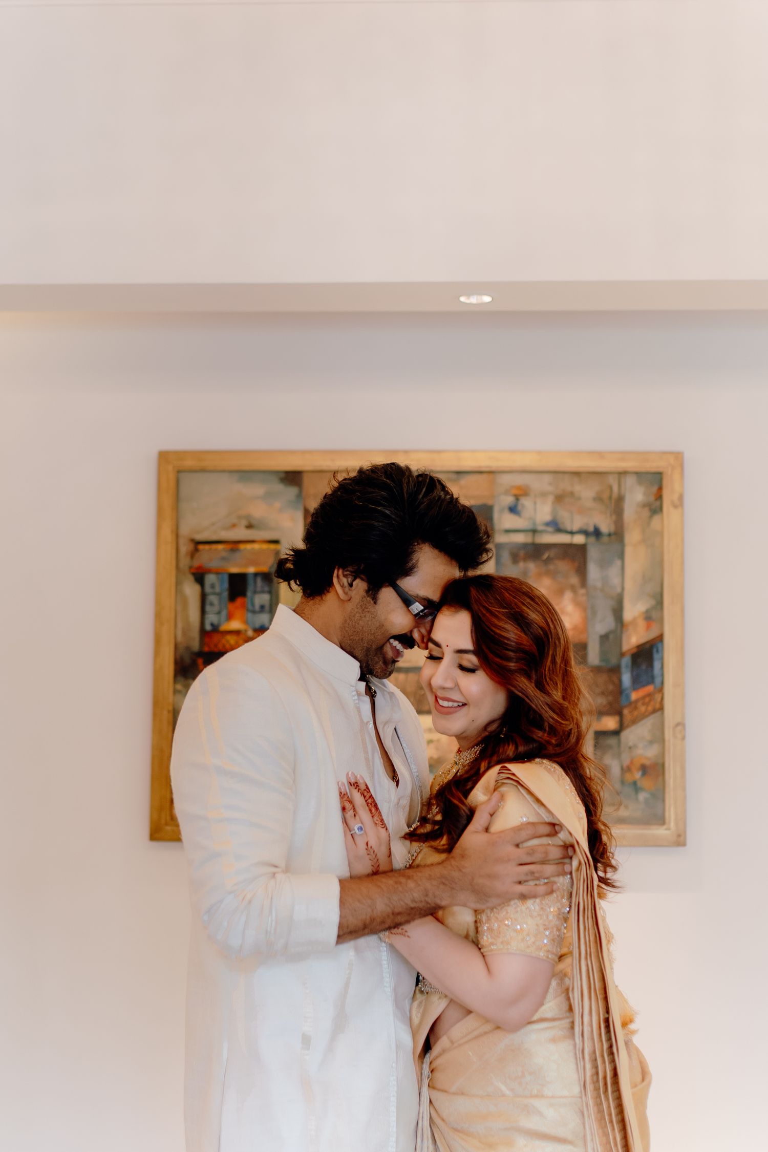 Romantic couple in white outfits sharing intimate moments against a light background.