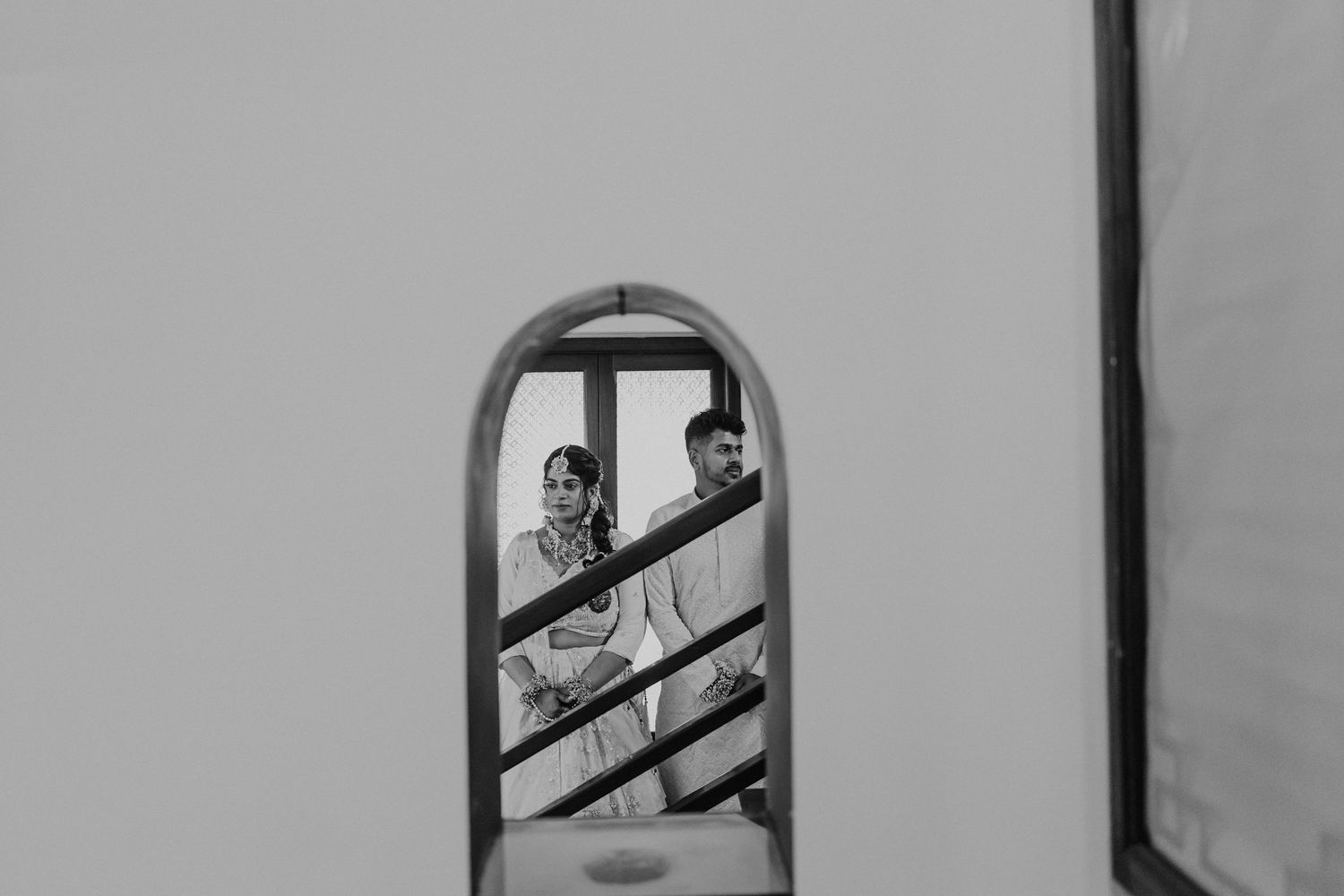 Black and white photograph showing a person looking through prison bars in a dramatic composition.