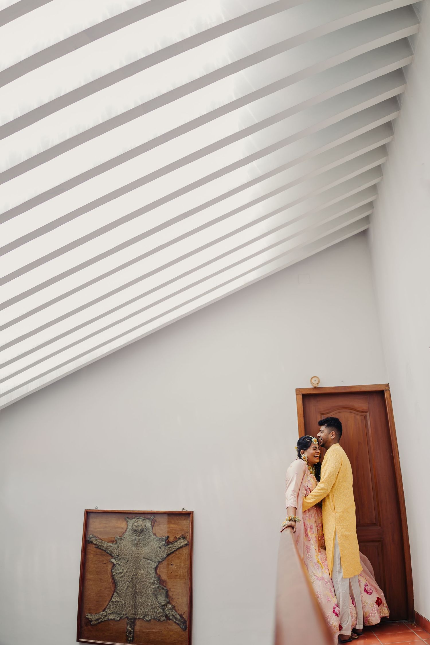 A sequence of images showing someone in a yellow coat entering through a wooden door in a white modern interior.