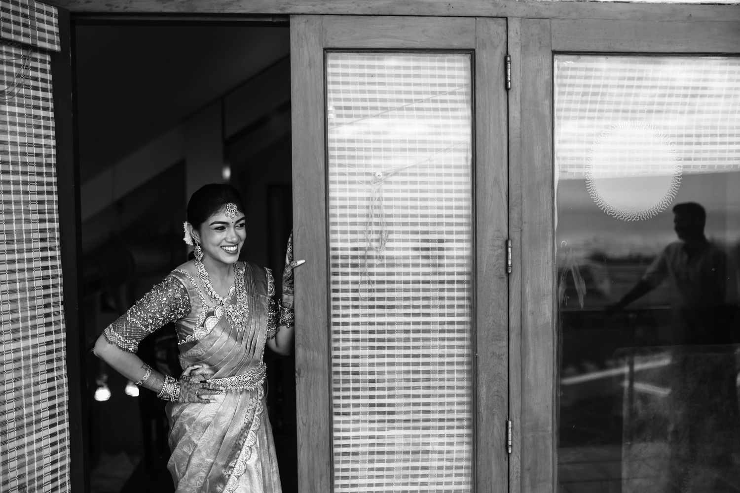 A black and white photo strip showing multiple window frames with venetian blinds and silhouettes.