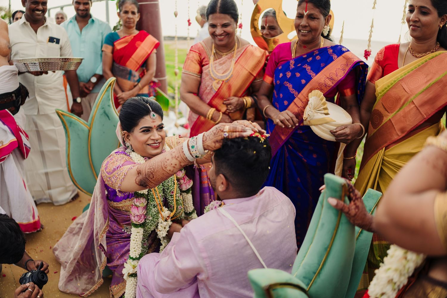 Guests participate in a traditional South Indian wedding ceremony wearing colorful saris and traditional attire.