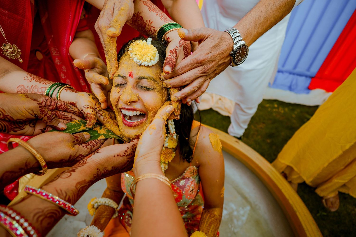 Traditional Indian wedding ceremony rituals being performed with turmeric paste application during Haldi ceremony.