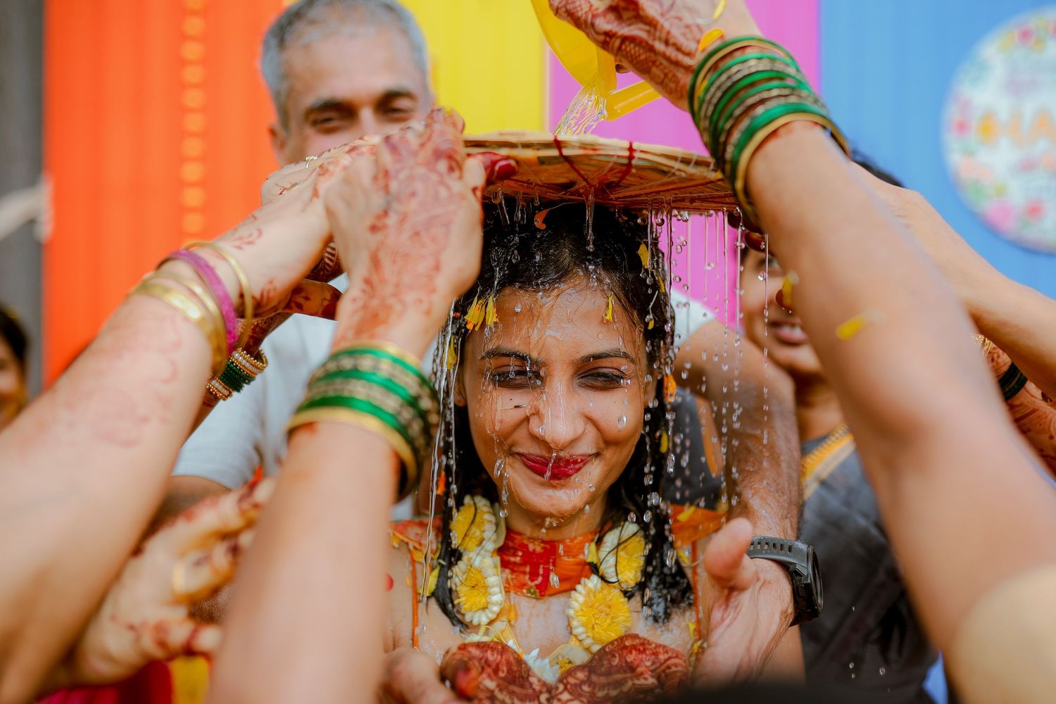 People dancing and celebrating at a colorful festival with yellow and orange hues in the background.