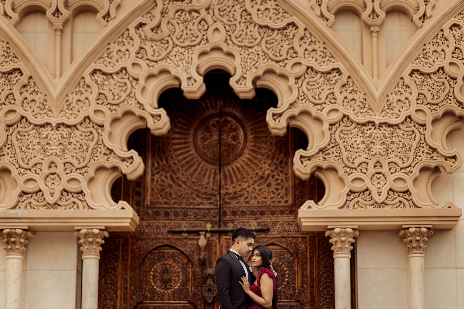 Ornate Moorish architectural details with intricate carvings and arches in beige stone at the Alhambra palace.