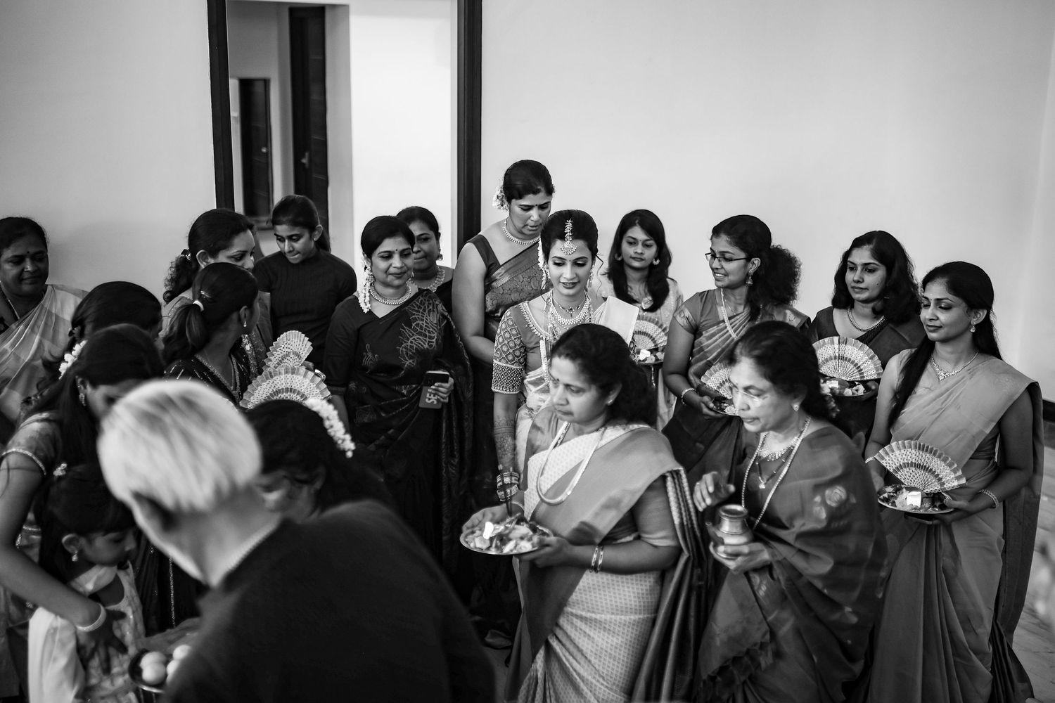 A group of people gathered in a room smiling and socializing at what appears to be an informal event or gathering.