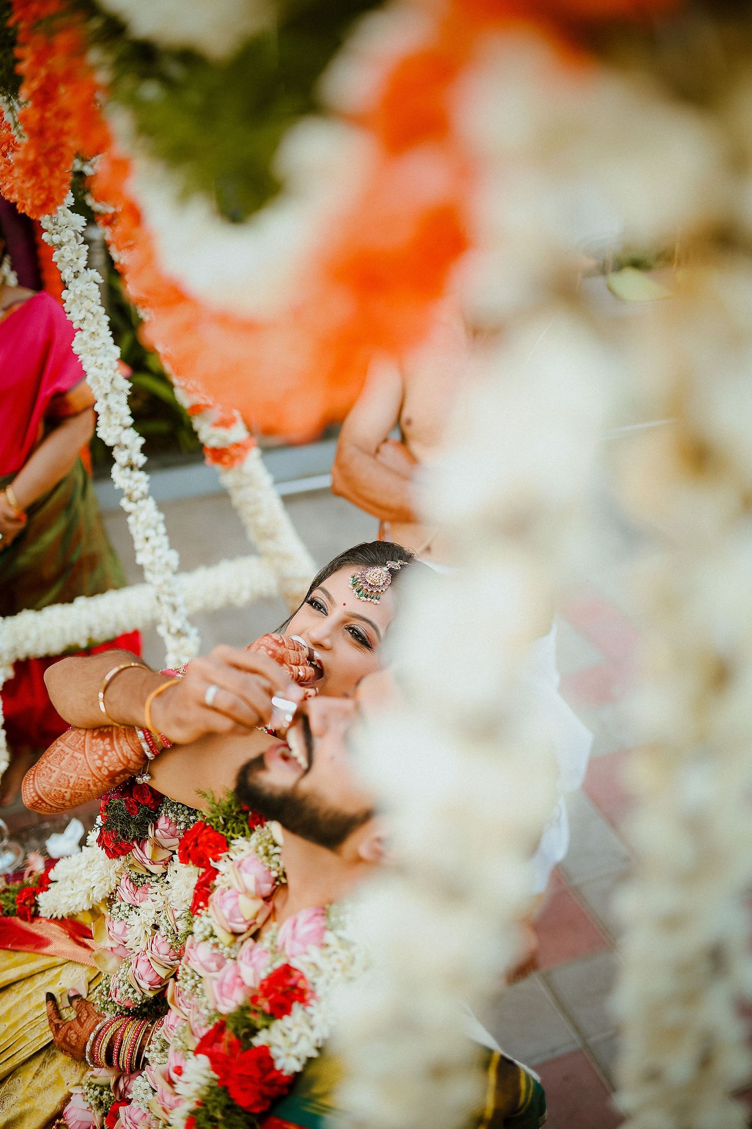 Traditional Indian wedding ceremony with floral decorations and henna-adorned hands.