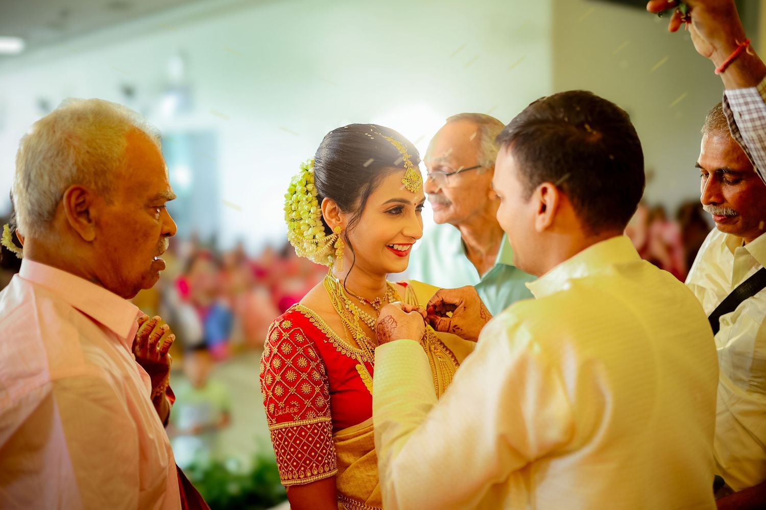 People gather at a festive celebration event with warm lighting and joyful interactions.