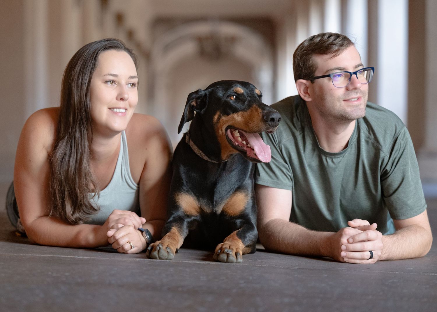 A couple lying on floor for casual indoor portraits with their dachshund.