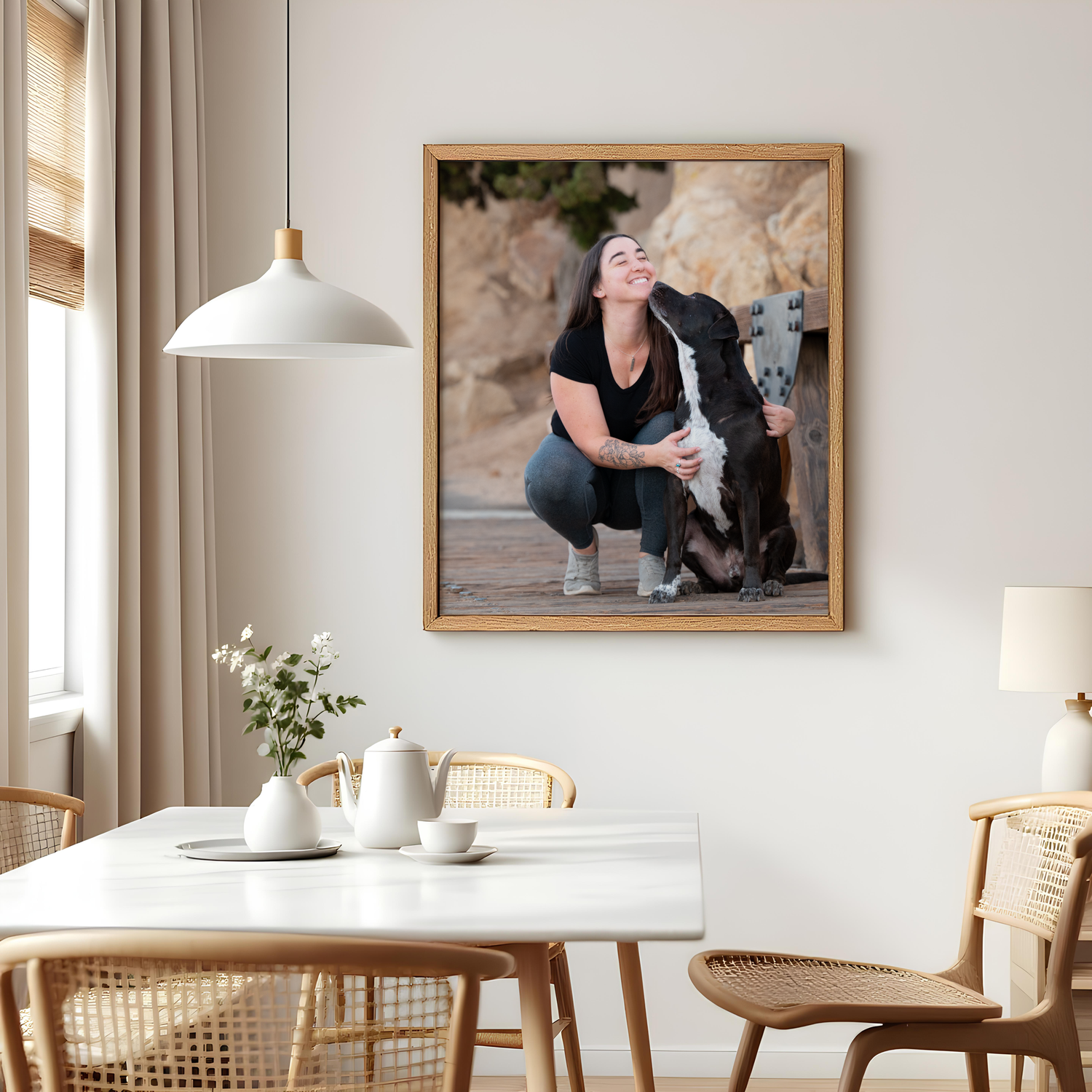 Modern Scandinavian dining room interior with wooden furniture and framed artwork on white walls.